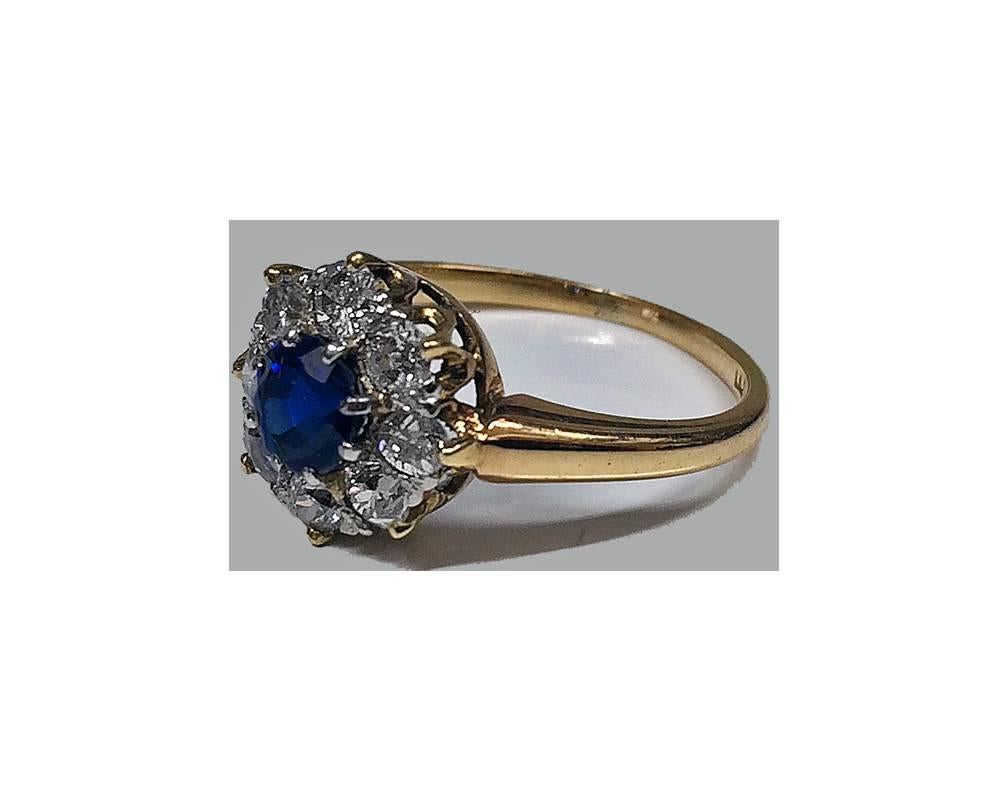 Antique 18K Sapphire and Diamond Ring, English C.1910. The cluster Ring set with a round facetted medium, moderately strong Blue Sapphire, approximately 0.33 ct, approximately VS2 (type 11) clarity, with a surround of eight round old cut Diamonds,