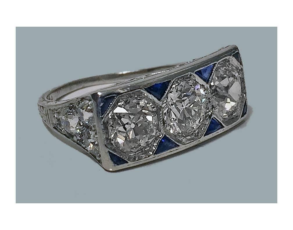 Art Deco Platinum Diamond Sapphire Ring, C.1920. The rectangular horizontal form ring, milligrain octagonal set with three old european cut diamonds, and three old cut diamonds at each shoulder, approximately 2.85 ct, total diamond weight, the three