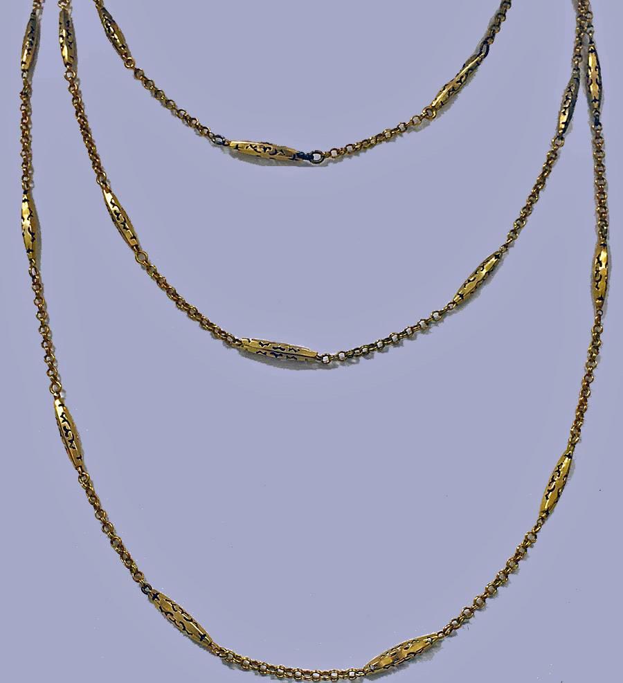 Antique 19th century Muff Chain, English C.1890. The 9ct chain with alternating pierced torpedo and intertwining link chain between, suspending gold swivel. Length approximately: 52inches. Weight: 13.6 gm.