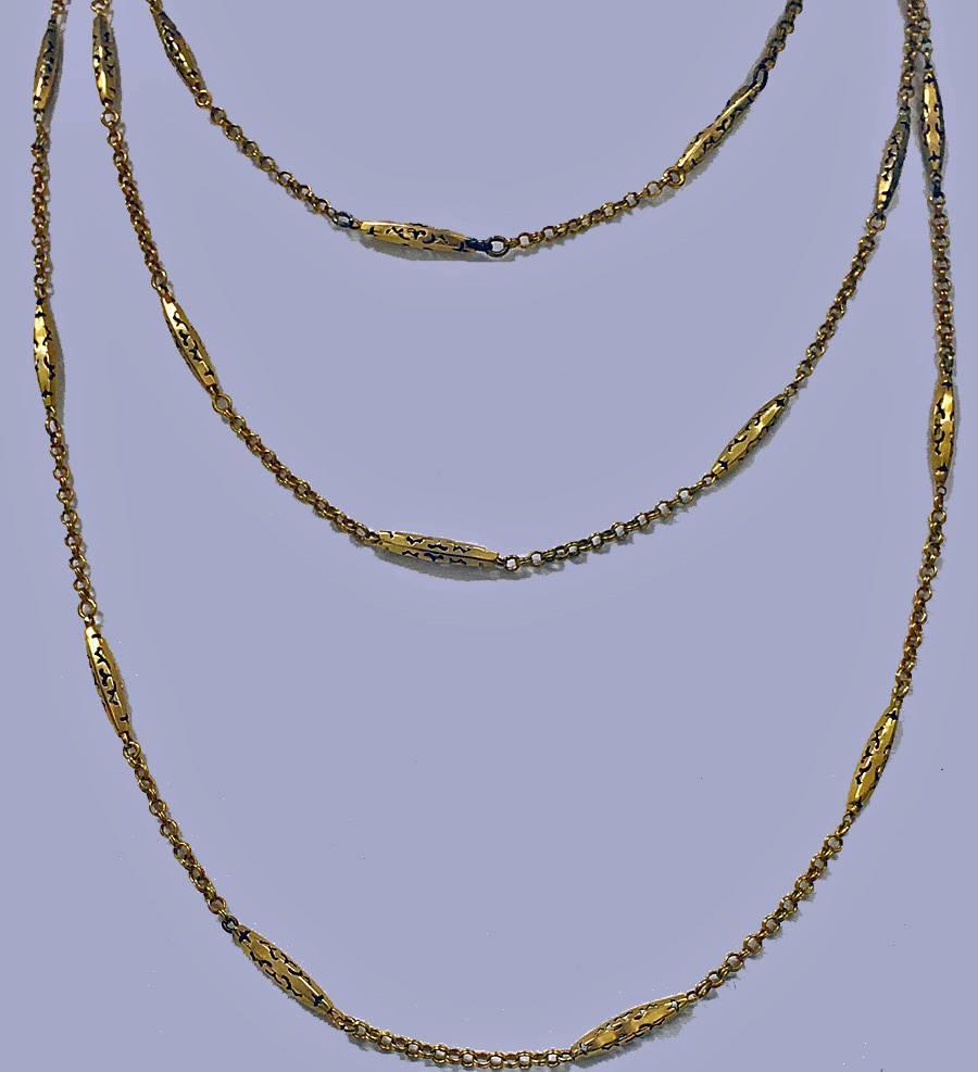 Antik 19. Jahrhundert Muff Kette, Englisch C.1890. Die Kette aus 9 Karat mit abwechselnd durchbrochenem Torpedo und dazwischen verschlungener Gliederkette, an der ein Goldwirbel hängt. Länge ungefähr: 52Zoll. Gewicht: 13,6 g.