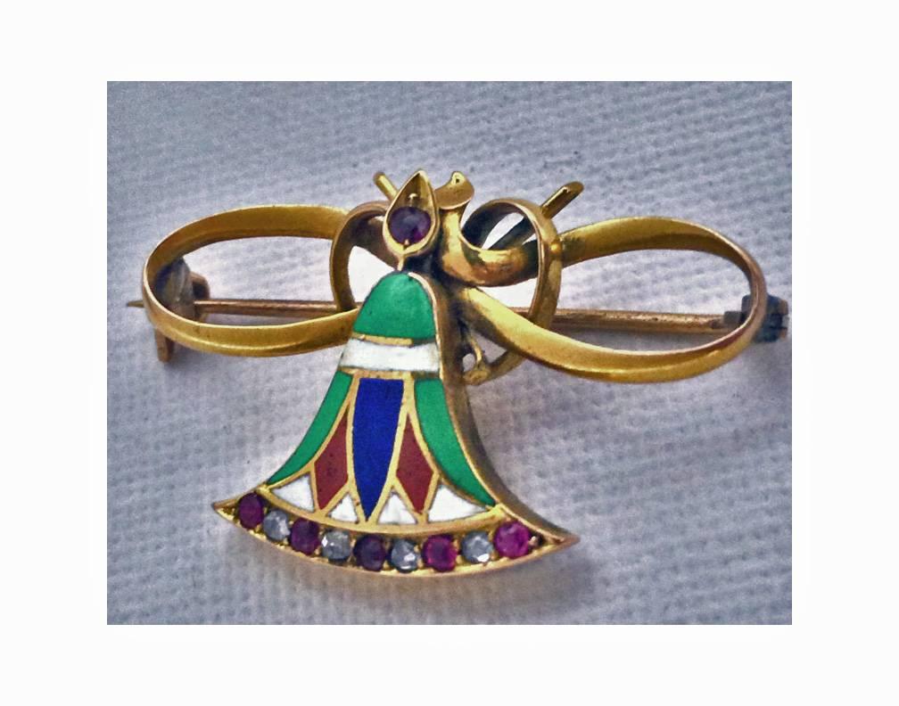 Continental 15K (acid tested) enamel Ruby and Diamond Egyptian revival butterfly brooch, C. 1900. The butterfly body with painted green, white, blue and orange enamel accented with 5 small rubies and 4 small old rose cut diamonds; the eye inset with