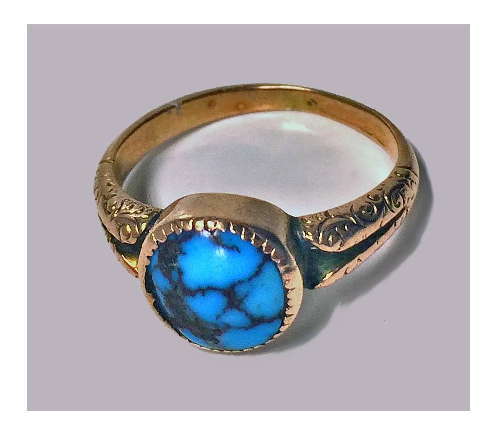 English Arts & Cafts 9k and Turquoise Ring, Birmingham 1906. The ring set with a cabochon t urquoise, deeply bezel set, split design foliate engraved shoulders, plain shank, hallmarked on interior. Total item weight : 4.2 gm. Ring Size: 9