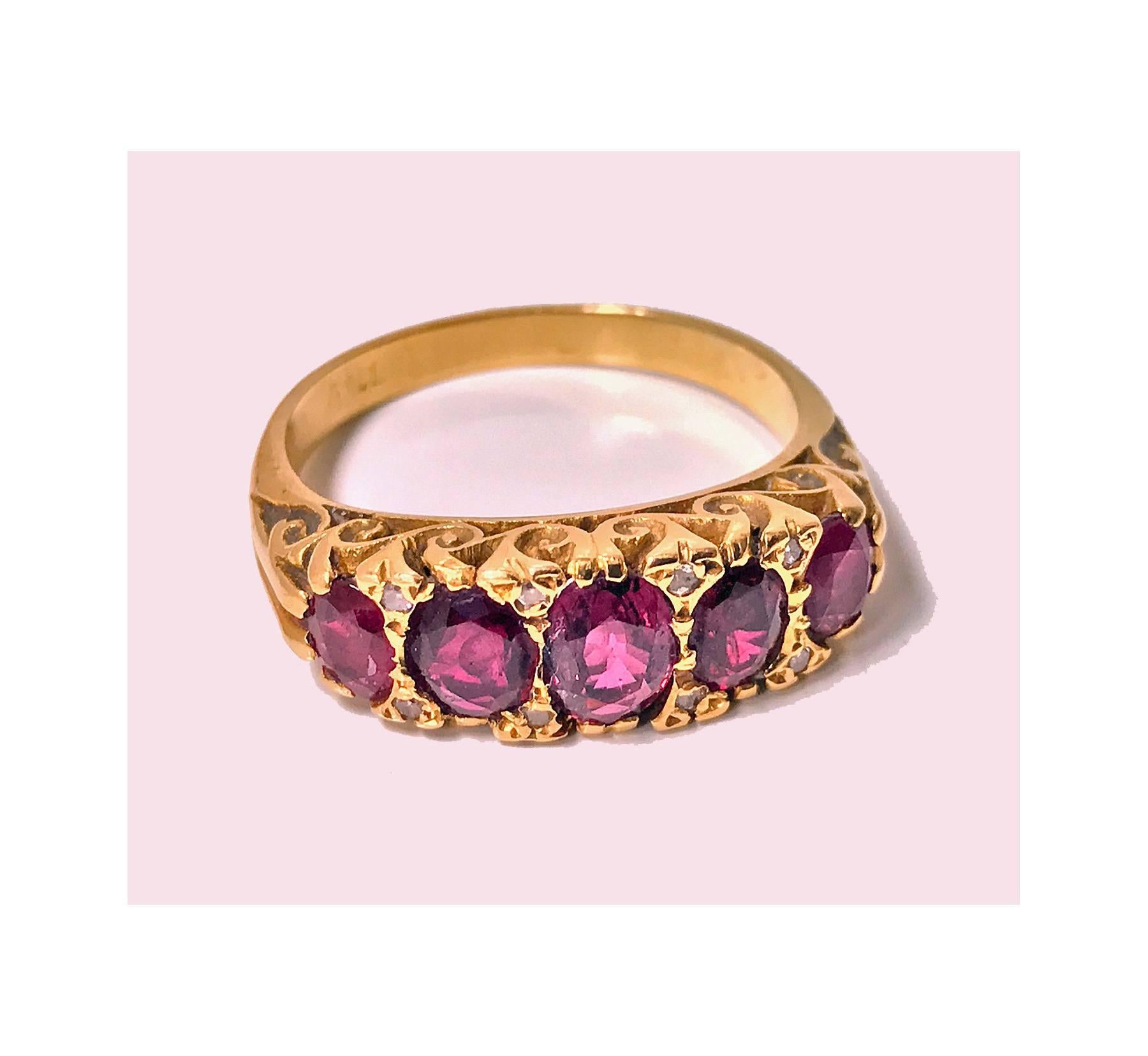Antique Victorian five stone half hoop Ruby and Diamond 18K Ring, C.1900. The Ring comprising of five graduated oval faceted Purple Red Rubies, weighing a total of approximately 3.00 ct. accented at each corner with a small rose cut diamond. The