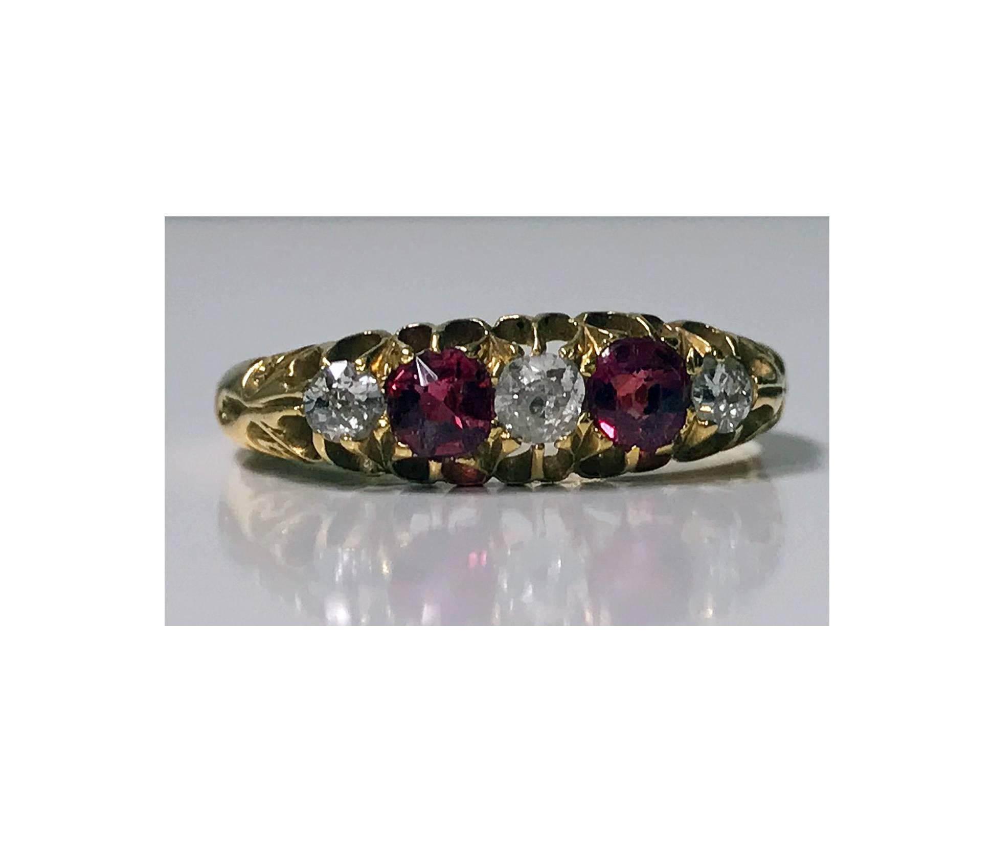 Antique 18K Diamond and Ruby Ring, C. 1900. The Ring set with three old cut diamonds, total diamond weight approximately 0.20 ct, average SI clarity, average I-J colour, and two cushion red Rubies, total ruby weight approximately 0.30 ct, carved