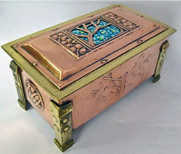 Arts and Crafts Enamel, Copper and Brass Box, C.1900. The box of four turned rivet bracket brass cornices, the panelled copper body with stylised arts and crafts decoration, the cover with turquoise, white and green pebble design enamel background.