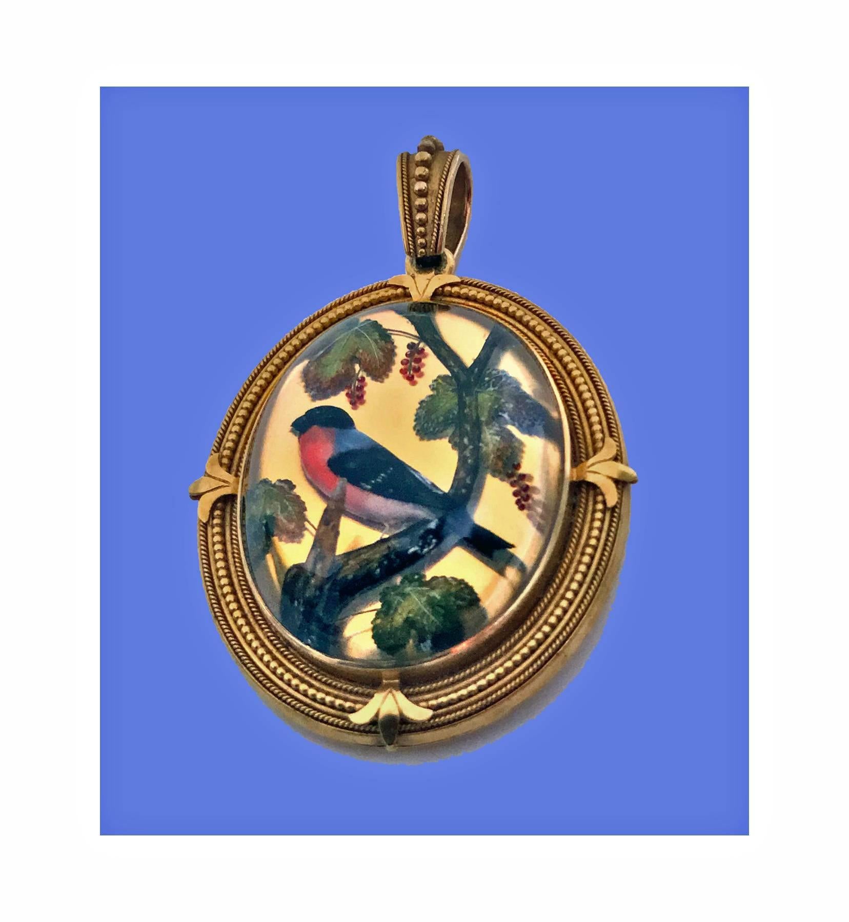 Very Fine 19th century Gold Reverse Intaglio painted Crystal `Essex Crystal’ large Pendant, English, C.1880. The deep oval cabochon rock crystal, carved and hand painted depicting a bullfinch perched on branch with leaf foliage and berries surround.