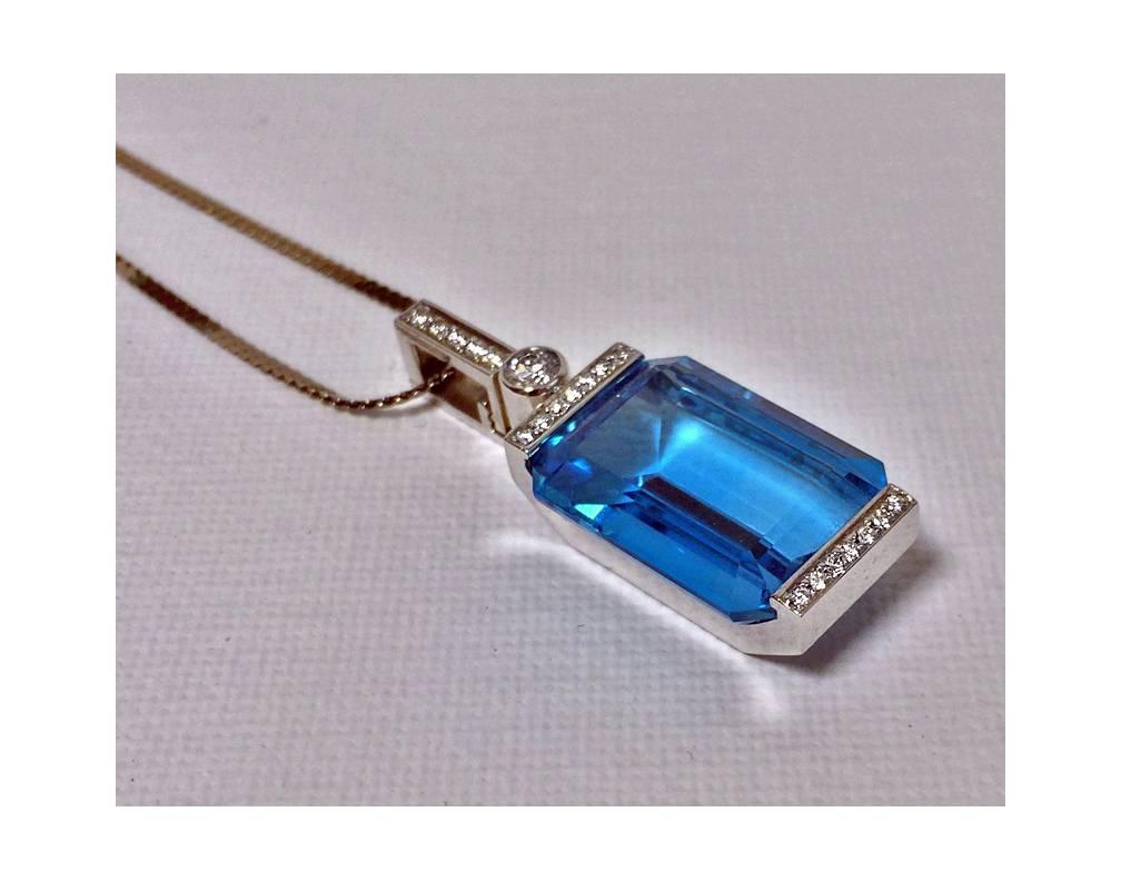 18K white gold Diamond and Blue Topaz Pendant. The Pendant set with a large rectangular step cut blue topaz, approximately 18 x 15 mm accented with 20 small round cut diamonds, 0.48 ct, TDW,  average SI clarity, average G colour, together with 14K