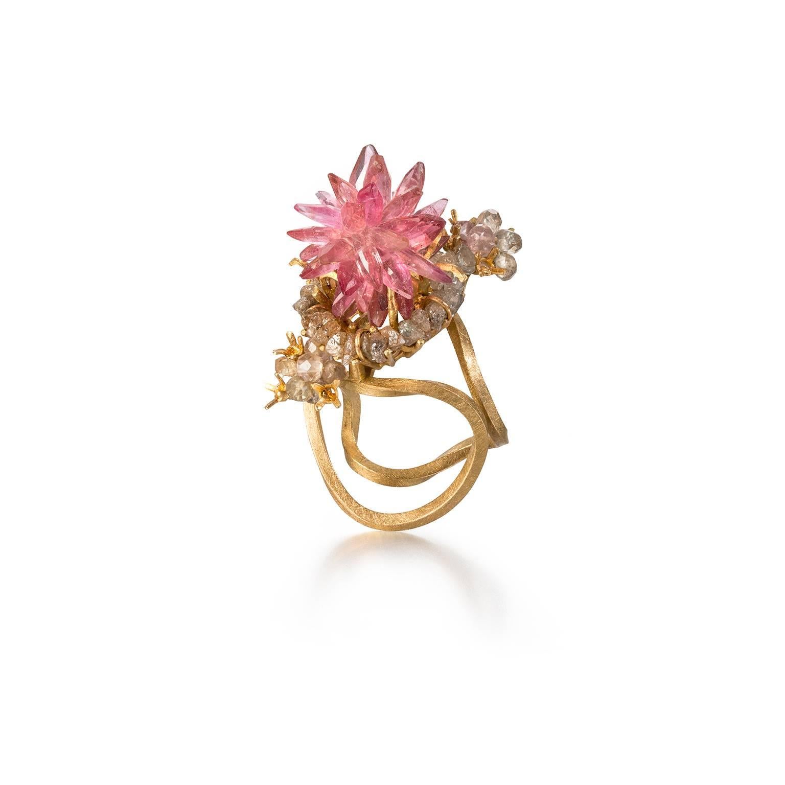 Unique sculptural 18t Gold Cocktail Ring by Donna Brennan. Featuring a star burst of Pink Tourmalines delicately framed by a ring of cognac Rough Diamonds and a cluster of champagne Sapphires. Double ring shank in approx. size 4.5 (size I 1/2), can