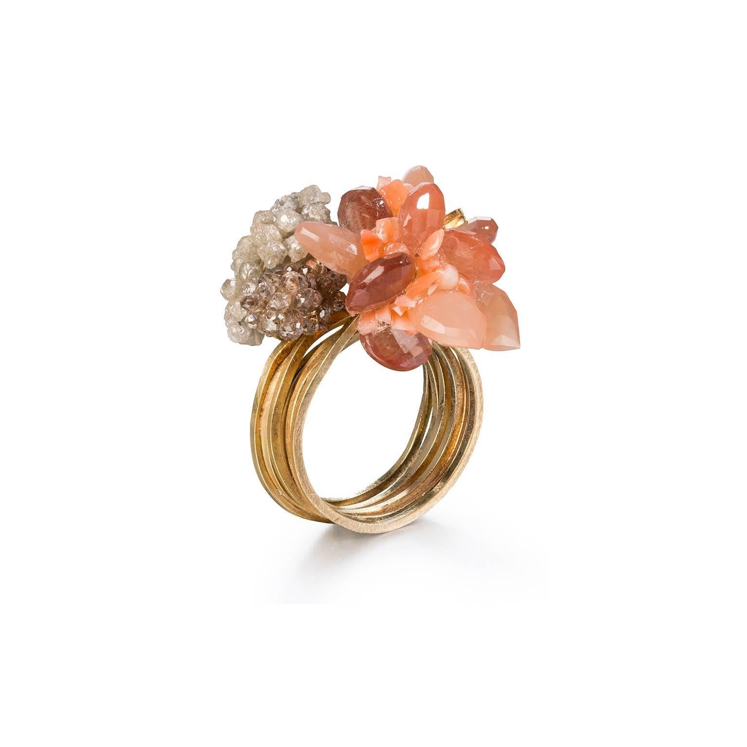 Unique sculptural 18t Gold Cocktail Ring by Donna Brennan. Featuring a star burst of Sun & Moonstones encrusted with crushed Coral, delicately framed by a swathe of cognac faceted Diamonds, and silver & black rough Diamonds. 7 ring shanks in approx.