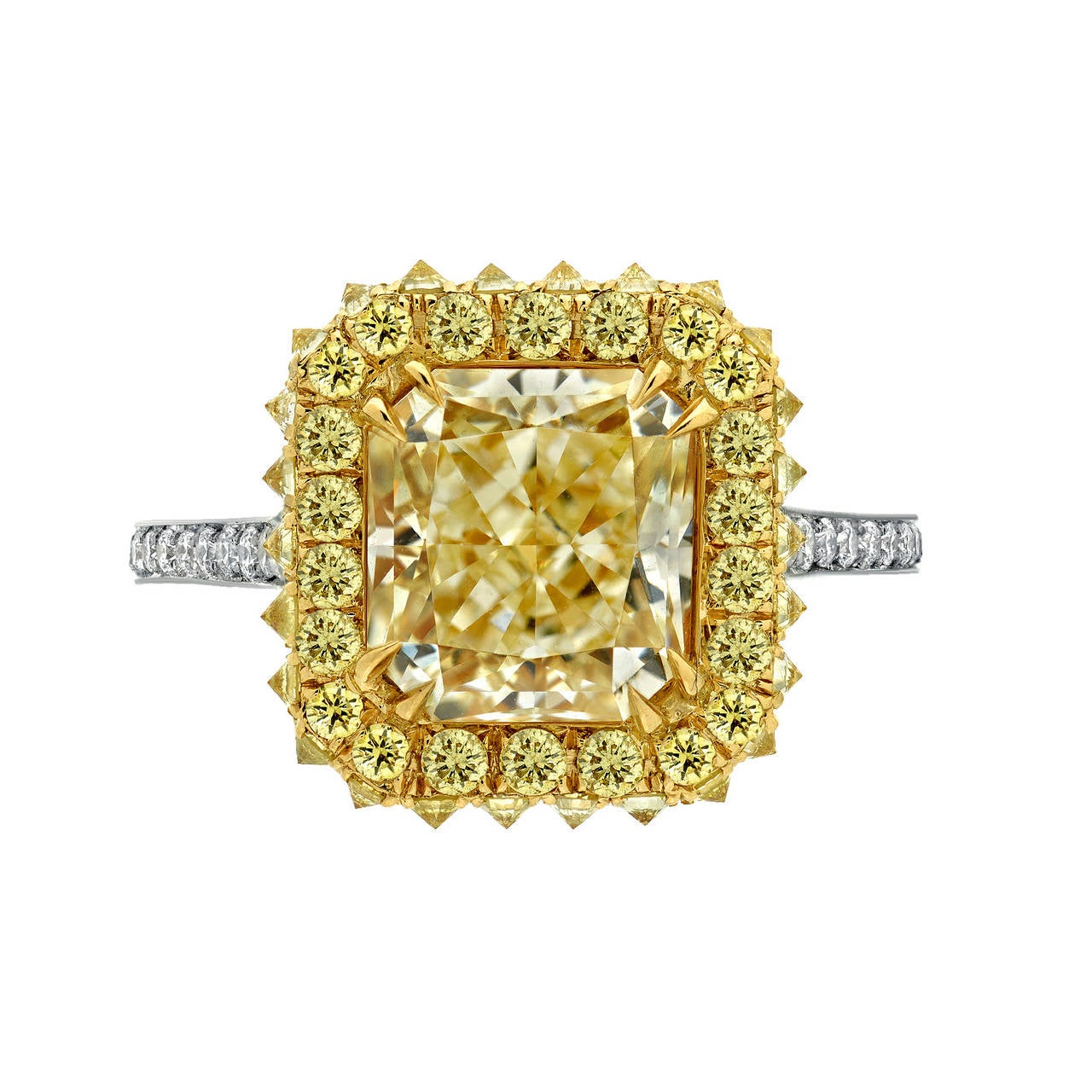 An exceptional and very bright 3.02ct radiant-cut light yellow diamond, VVS2, is surrounded by a row of fancy yellow diamonds on top, and inverted set fancy yellow diamonds on the sides, totaling 0.72ct. The tapered shank is gradually set with round
