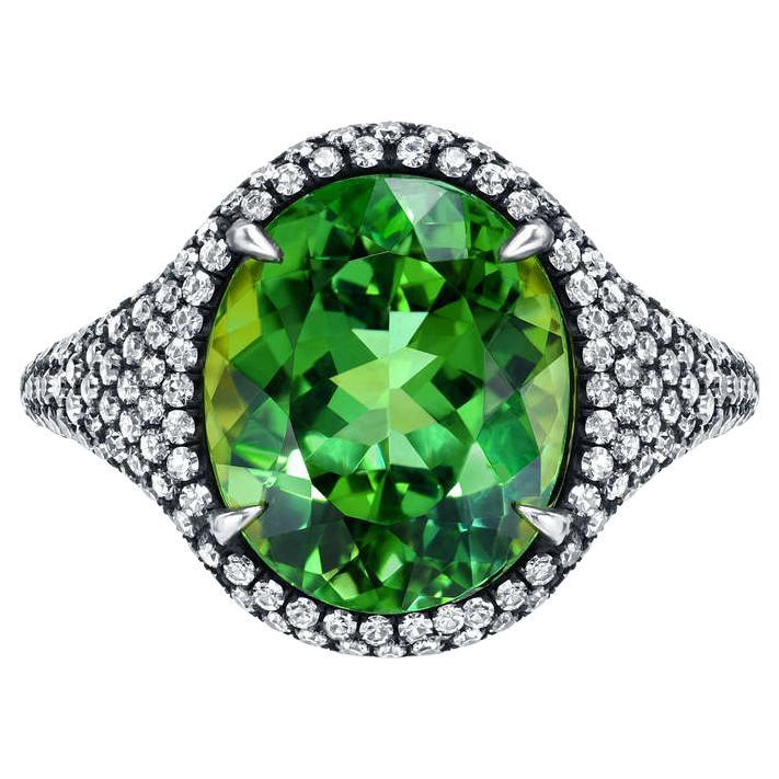 Unique 5.40 carat oval Mint Green Tourmaline ring, surrounded by a total of 1.54 carats of diamonds. 
Crafted by extremely skilled hands in 18K yellow gold topped with black-finished silver.
Ring size 6. Re-sizing is complimentary upon