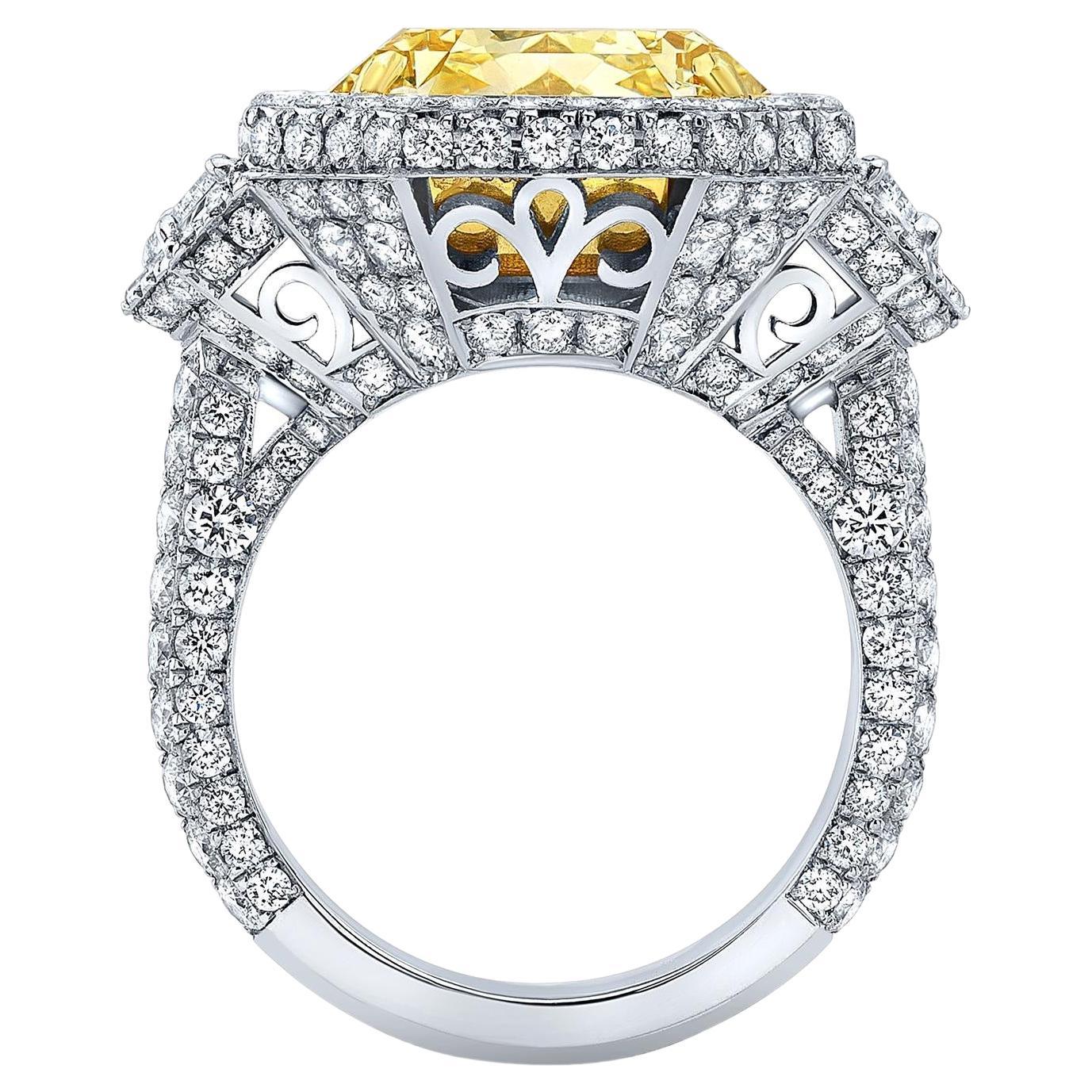 Magnificent 10.43 carat radiant cut Fancy Light Yellow Diamond, SI2 clarity, flanked by a pair of 0.61 carat trapezoid diamonds, and a total of 3.38 carat round brilliant diamonds, are comprising this 18K white and yellow gold ring.
The GIA
