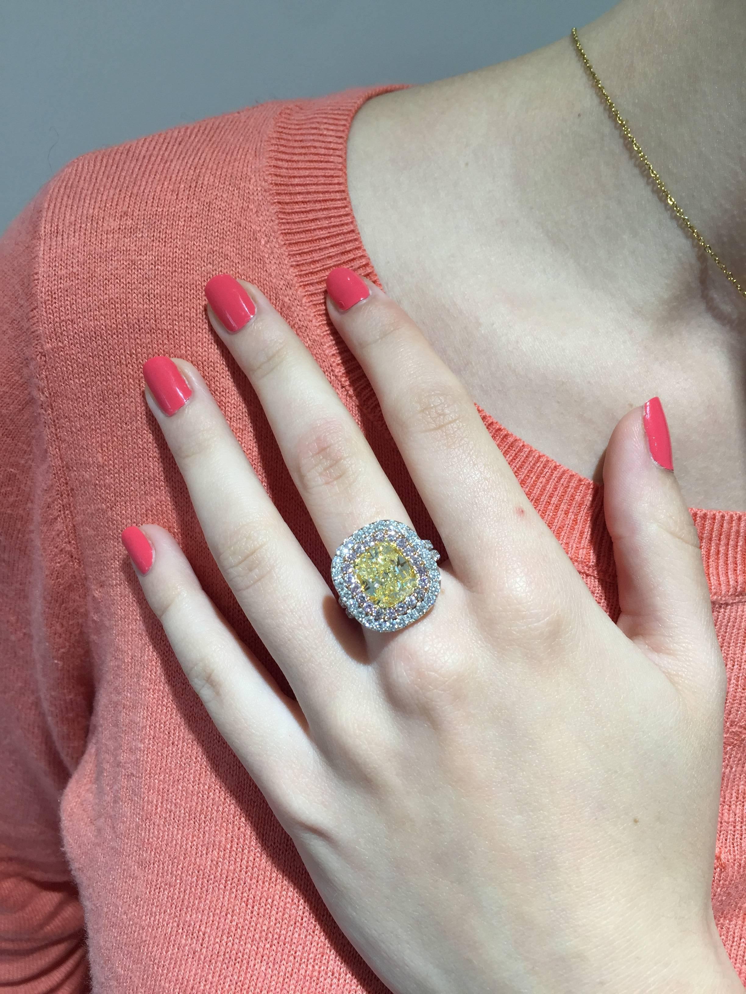 A sensational 4.55ct G.I.A. certified fancy light yellow, VS1 diamond, is surrounded by a total of 0.56ct round brilliant fancy pink diamonds, and a total of 2.06ct round brilliant G/VS diamonds. 
18K white and rose gold; crafted by hand in the