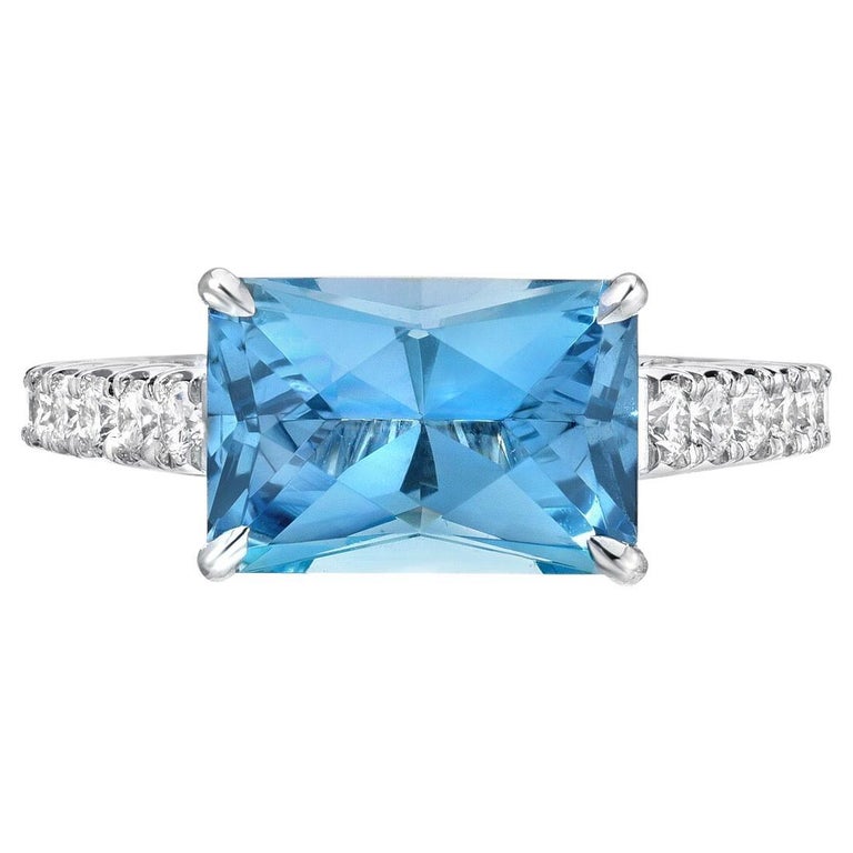 This custom emerald cut, natural Aquamarine weighing 2.59 carat, blends an emerald cut outline with a radiant cut, to maximize the brilliance of the gem. It is hand set horizontally in a striking 0.52 carat round brilliant diamond platinum ring for