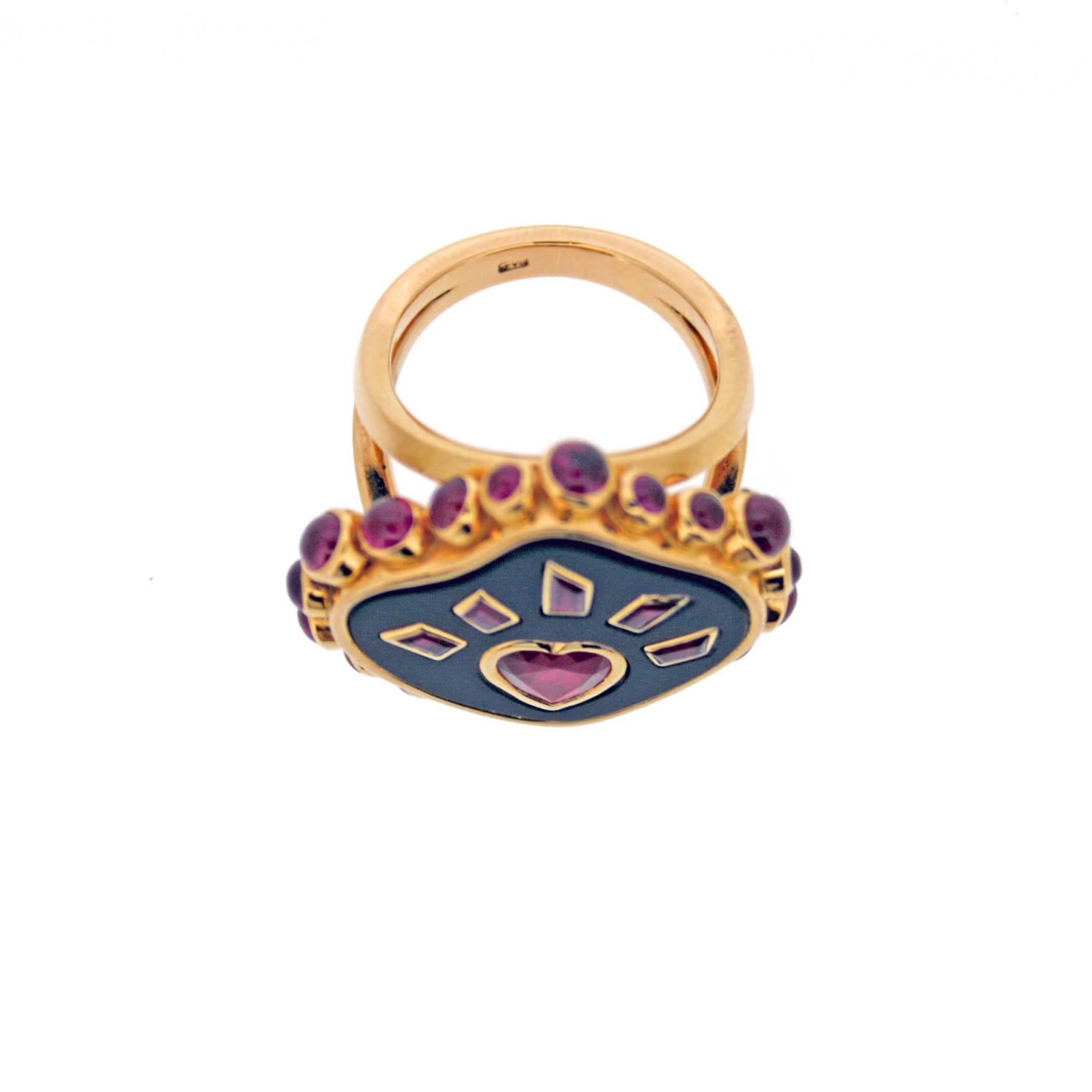 Flaming heart ring from the Cosmic collection.
Central plaque of onyx set with a graphic ruby flaming heart and rub over set cabochon rubies in 18ct polished yellow gold.
Onyx approximately 2.00cts.
Rubies approximately 3.99cts.
Finger size 50