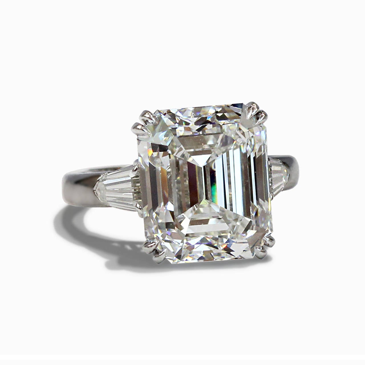 This exquisite platinum ring consists of 1 emerald cut diamond weighing 13.54cts having a color and clarity of GVS1 accompanied with a GIA Certificate. The center stone is flanked by 2 tapered baguette diamonds having a total weight of