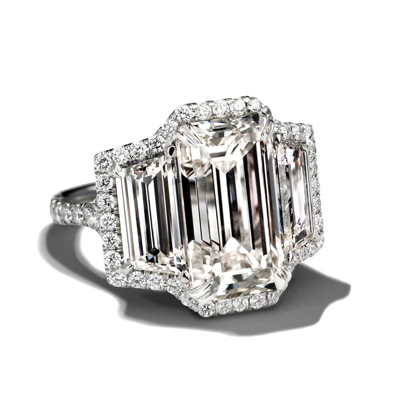 Wow! What a look for the money! 

A mesmerizing Emerald Cut Diamond is featured in this beautiful handmade platinum mounting. The center stone is 6.39cts and has a color and clarity of L VS1. The stone is flanked by 2 trapezoids with a combined