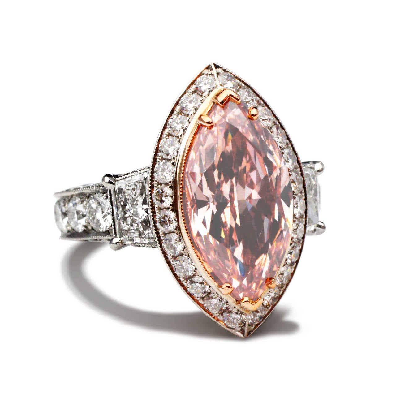 This remarkable 3.49 ct Marquise diamond ring is set in a micro pave setting. It has a unique fancy brownish pink color and has a clarity of S12 along with elegant matching trapezoids of 2.30 total weight. This ring is accompanied by a GIA