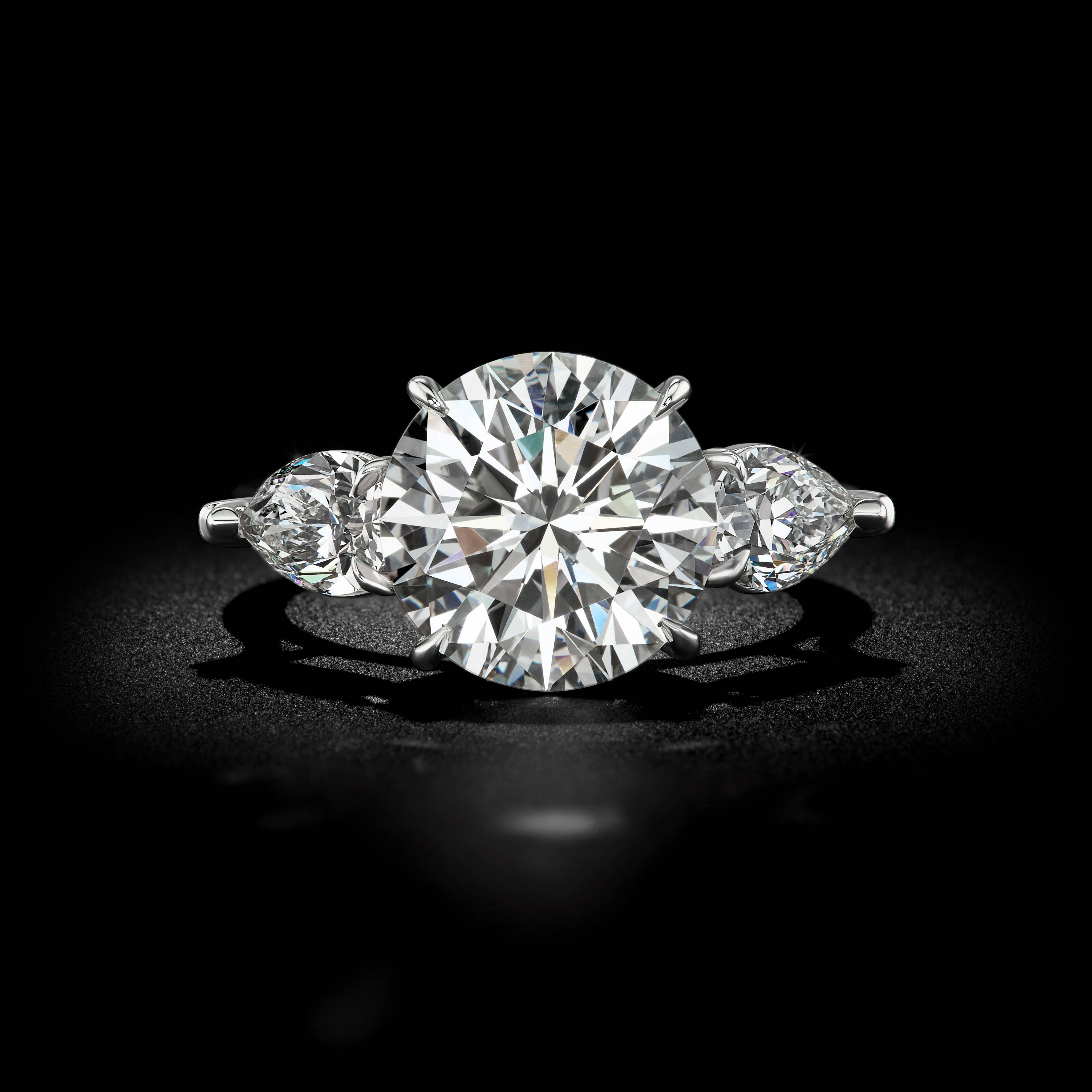 This exquisite 6.28ct I color SI2 accompanied with a GIA certificate. This Brilliant   round diamond is set in a David Rosenberg Platinum Mounting. Flanked by a matching pair of 1.52tw pear shape diamonds and has a color and clarity of I VS2.