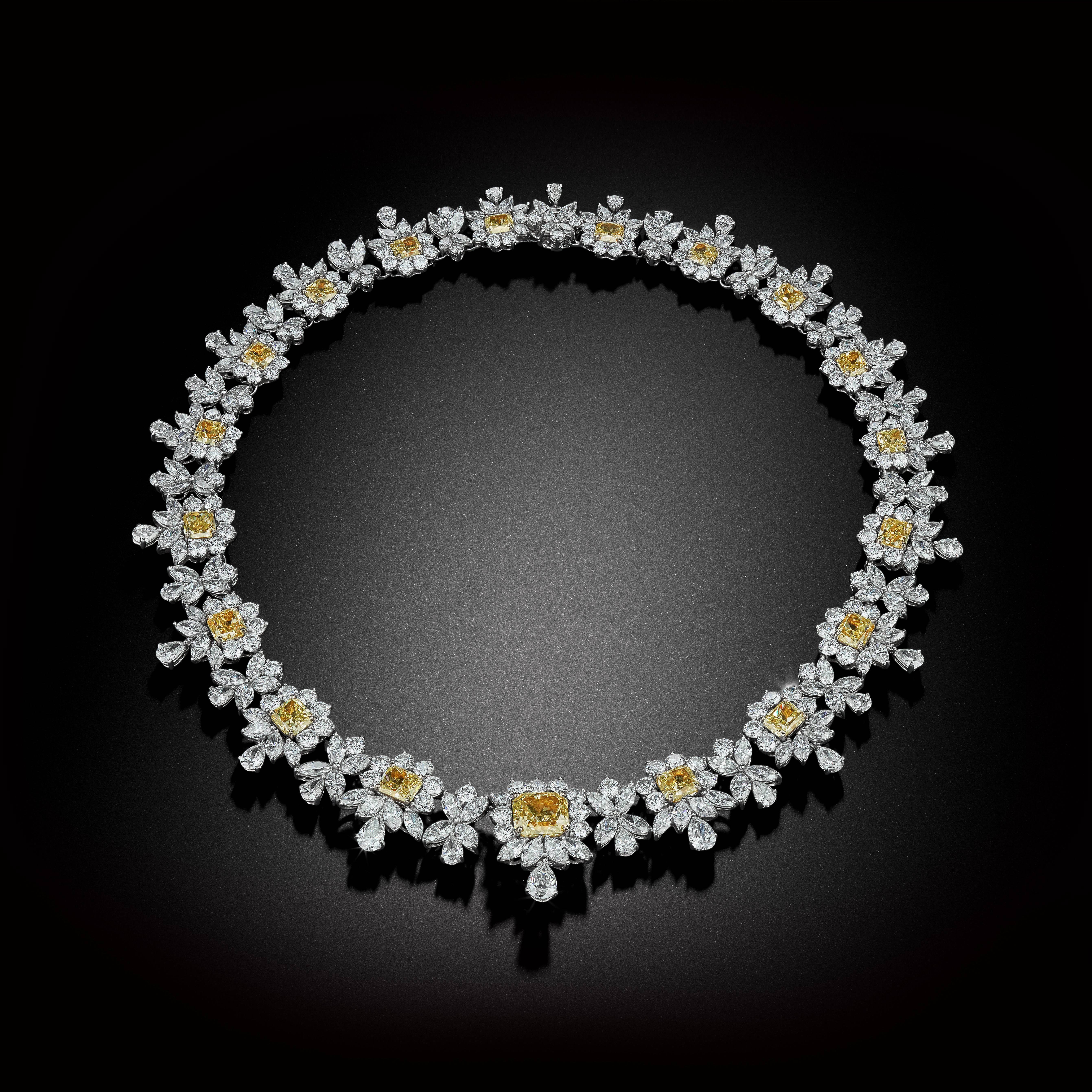A Platinum and 18kt White & Fancy Yellow Diamond Necklace features approximate combined total weight of 135.32ct of impeccable white marquise and pear shapes within floral motifs surrounding 19 incredibly rare radiant fancy yellow diamonds.

David