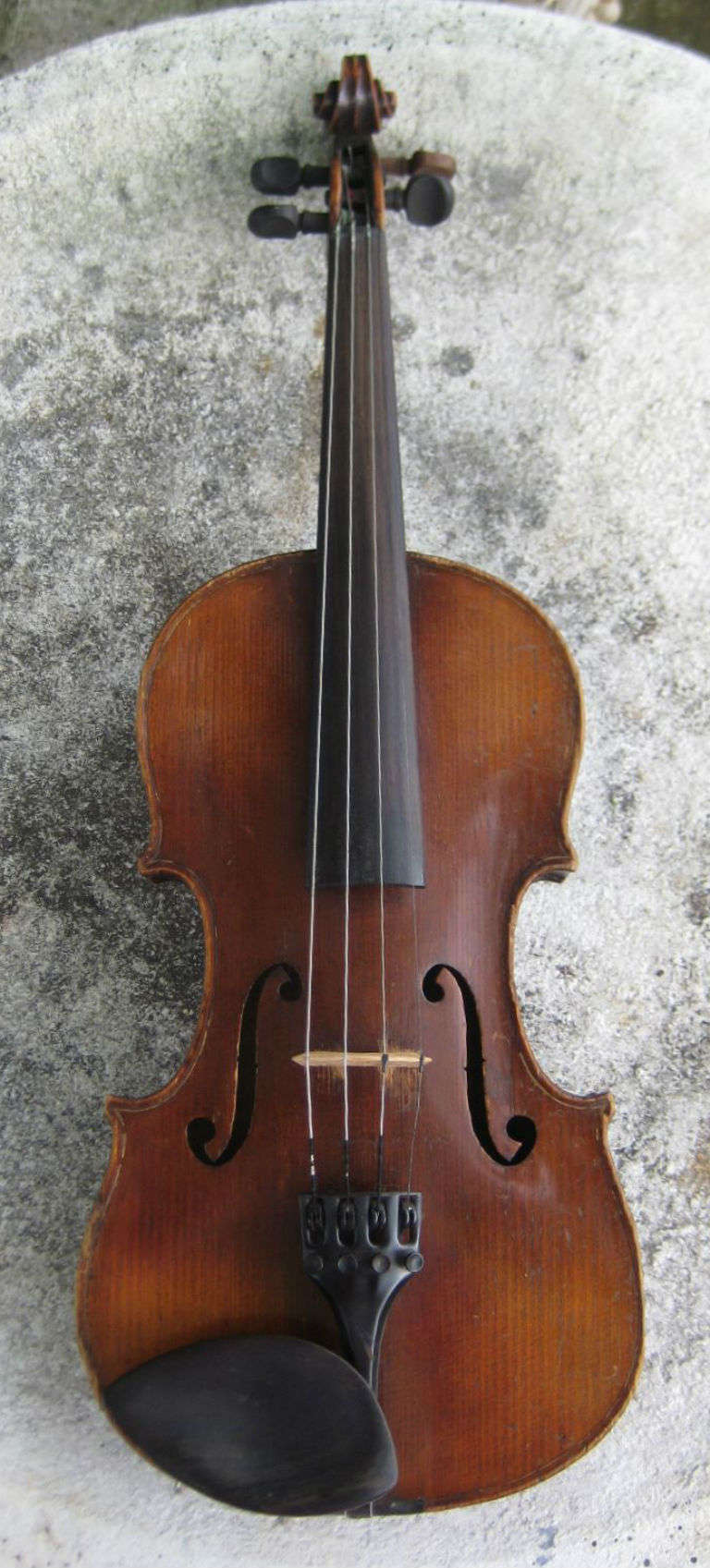 A full size violin with a two-piece maple back of slight descending horizontal curl, a spruce top and curly maple ribs, corner blocked and lined, ebony tuning pegs; labeled: Joseph Guarnerius fecit Cremonae anno 1711 (Cross) over IHS (Printed 17 and