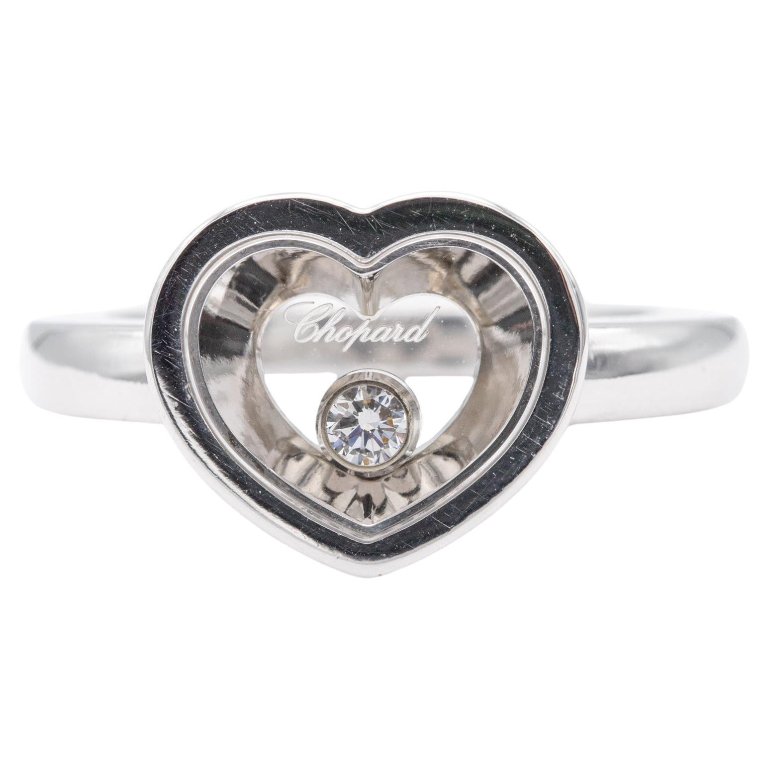 For sale is this wonderful and timeless Chopard ring. This heart shaped ring is from Chopards 'Happy Diamonds' collection. This 18 k white gold ring is holds one brilliant cut diamond which is set between two crystal glasses, making it able to move