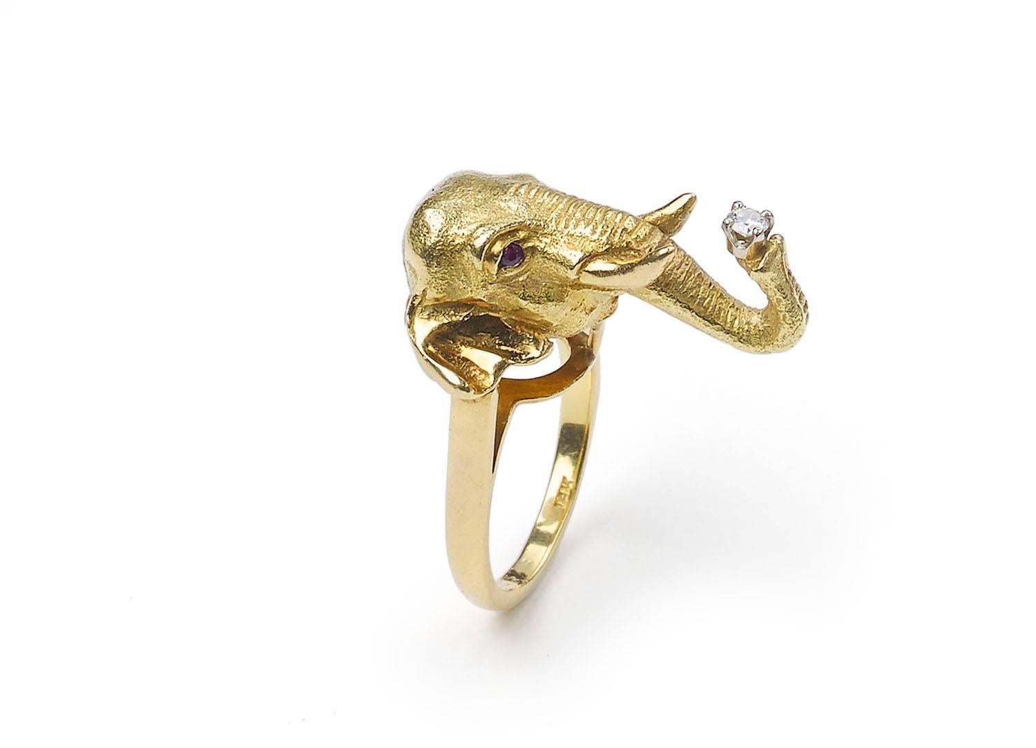 A gold elephant head ring, with ruby eyes and a round brilliant-cut diamond in the trunk. Circa 1990. Numbered 4037 stamped 18k. Finger size K½ UK, 5½ USA