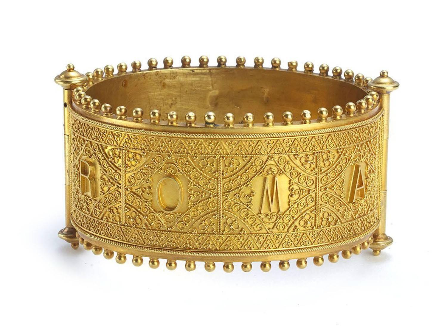 A 19th century broad hinged micro mosaic bangle, with Etruscan style fine bead and ropework decoration, the front is set with a rectangular micromosaic panel, after the work of Guido Reni on the ceiling of the garden pavilion of Palazzo Rospigliosi