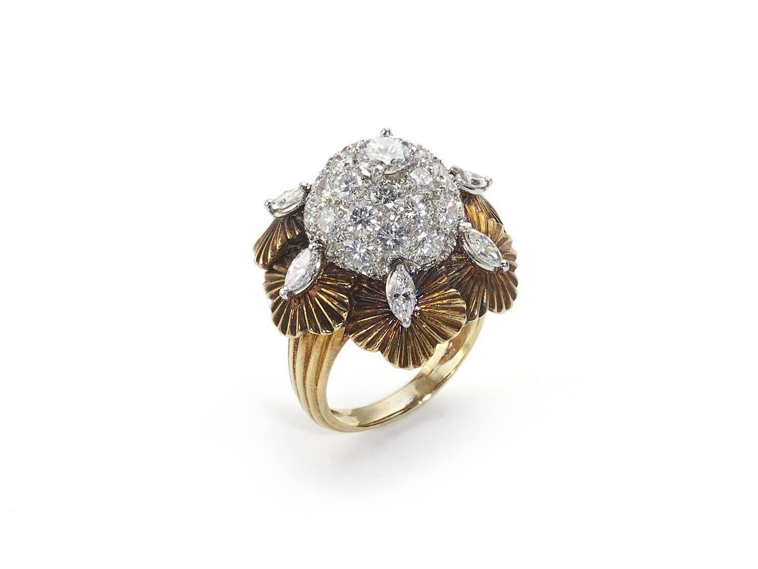 A vintage bombé diamond flower ring, pavé set with round brilliant-cut diamonds, surrounded by marquise-cut diamonds, on gold leaves, mounted in 18ct gold. Circa 1960s. Estimated total diamond weight 3.00ct 

Finger size M½ / USA 6¼