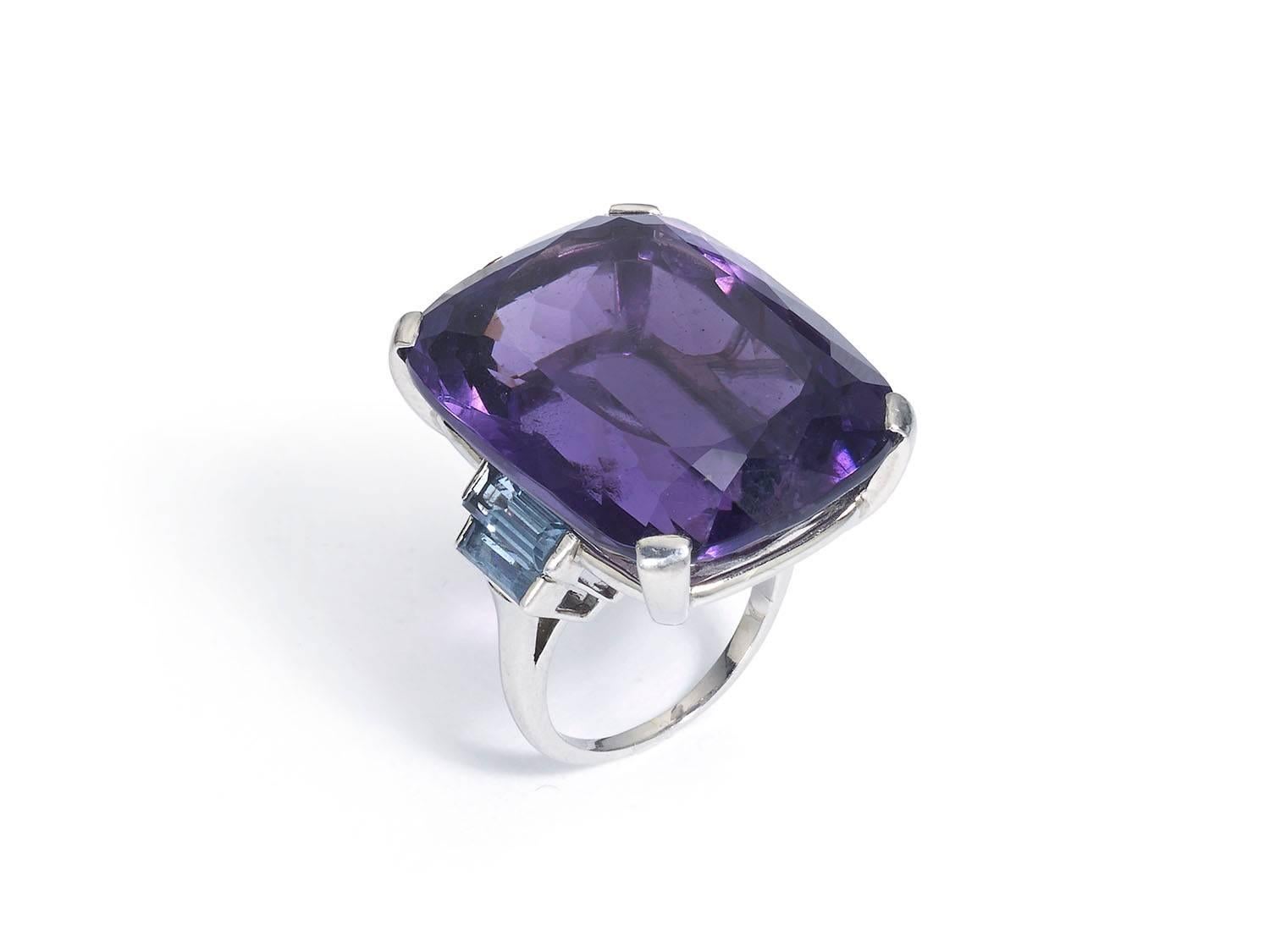 Amethyst and aquamarine cocktail ring, 18ct white gold ring, cushion cut amethyst weighing an estimated 47.00cts, with two baguette cut aquamarines set to each side, in 18ct white gold, Circa 1950's