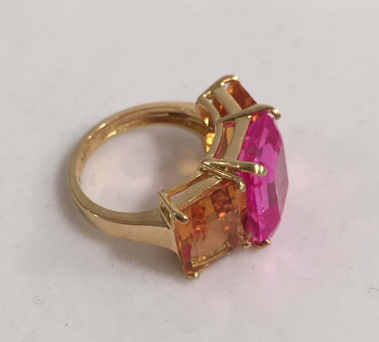18k Yellow Gold Three Stone Emerald Cut Ring with Citrine and Pink Topaz

Approximately an inch wide and half of an inch tall

The Three Stone Emerald Cut Ring can be made with any stone combination

Please contact us with any inquiries you may