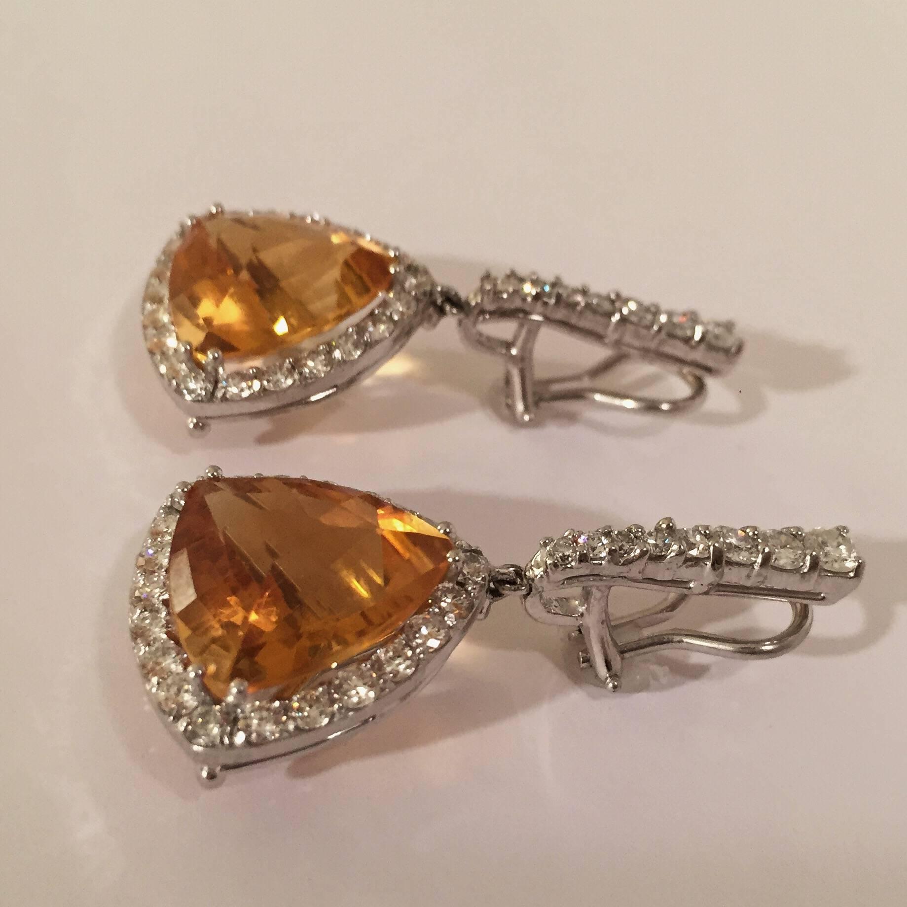 18kt White Gold hanging earrings with triangular cushion cut orange citrine surrounded  by approximately 4.50cts of White Diamonds.

The citrine is approximately 3/4