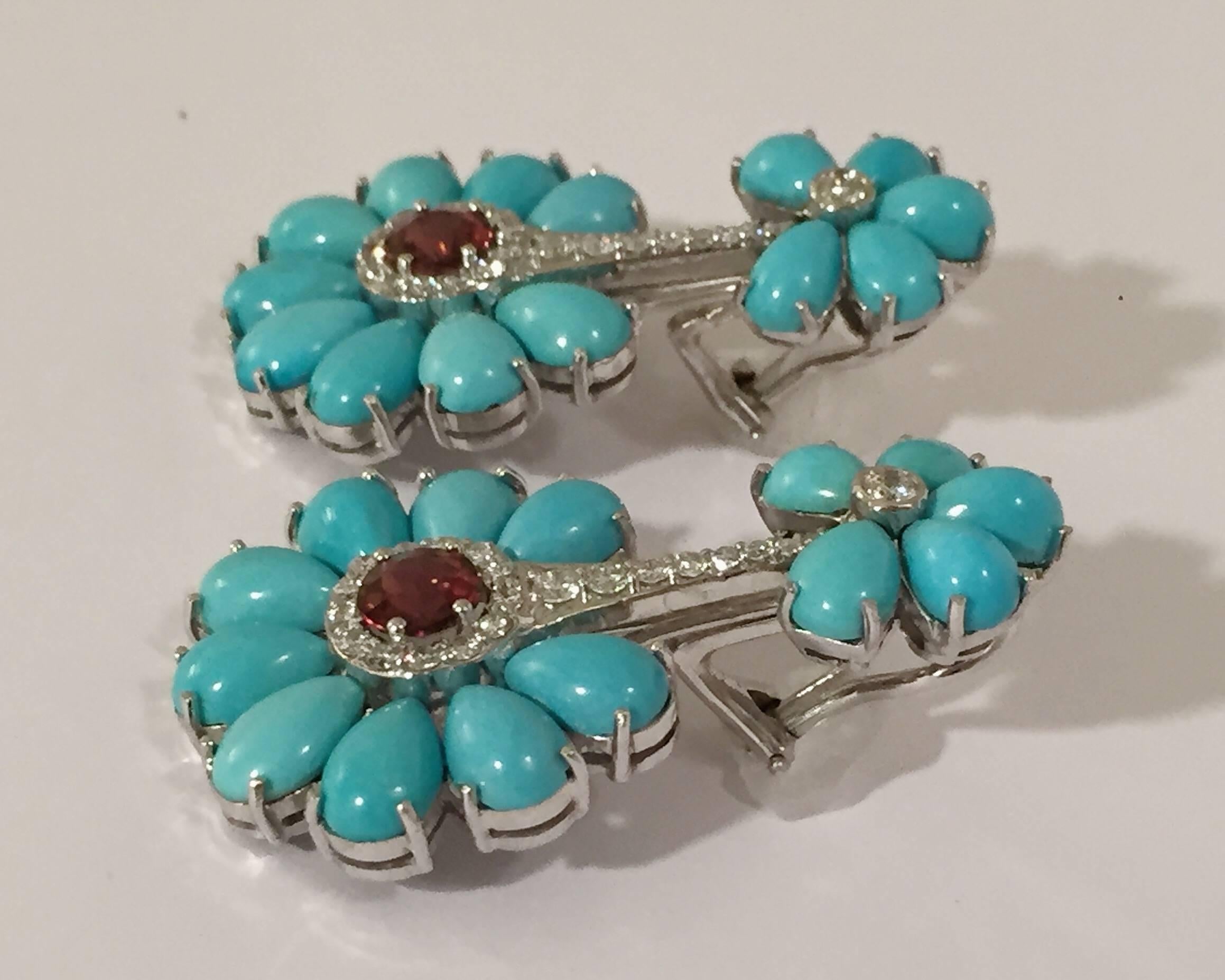 Elegant Turquoise Drop earring set in 14kt White Gold with Diamonds and Rubelite center with 28 pear shaped Turquoise .  The circular patterns frames rounds diamonds weighing approximately 1/50 cts and two faceted Rubelite.  The earrings can be made