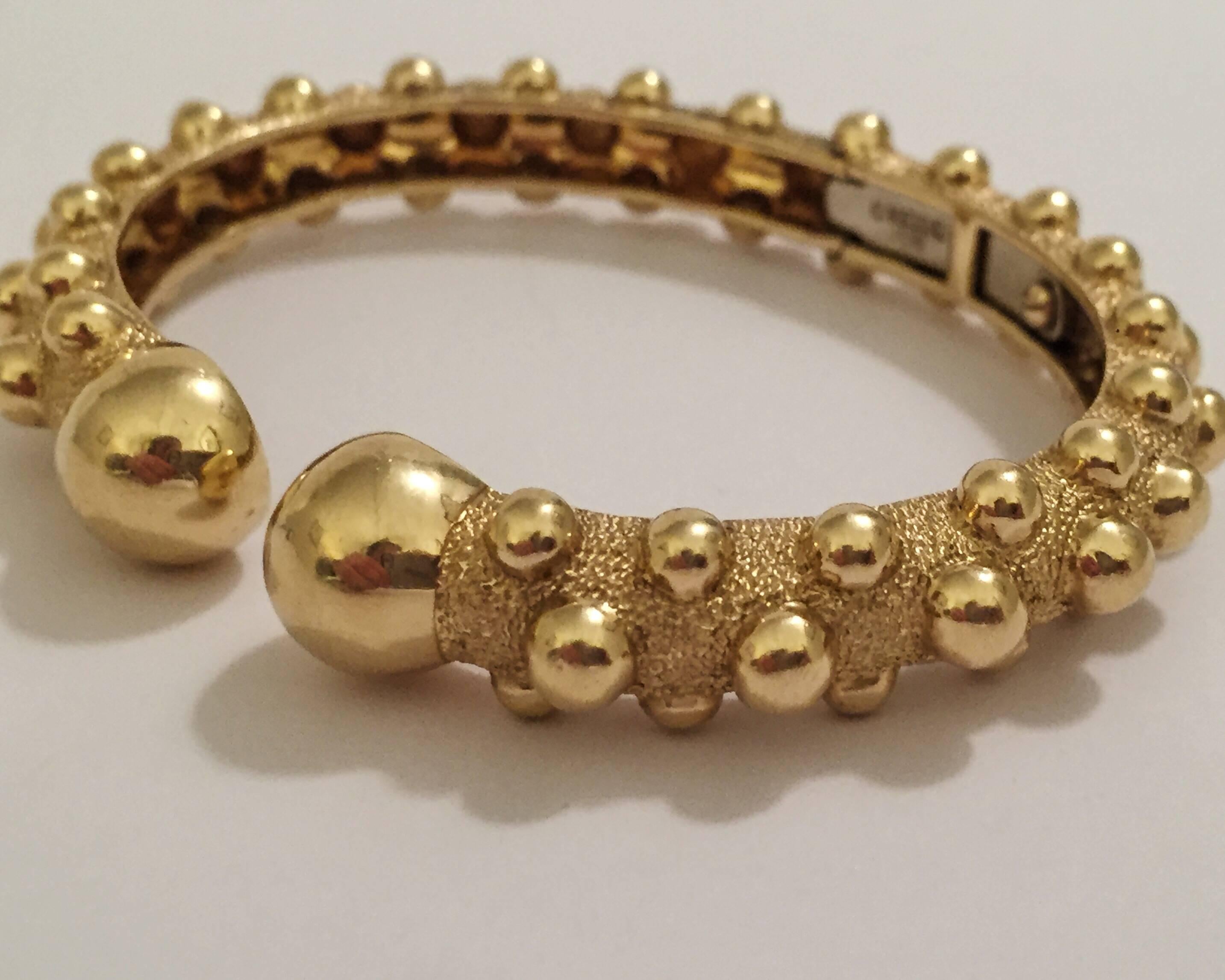 18kt Yellow Gold David Webb Gold hinged Cuff with beaded detail.  The open Cuff hinges in the middle.  The polished gold beading detail is completed with the large gold beaded ends of the cuff.

The cuff is small and measures 2 1/4