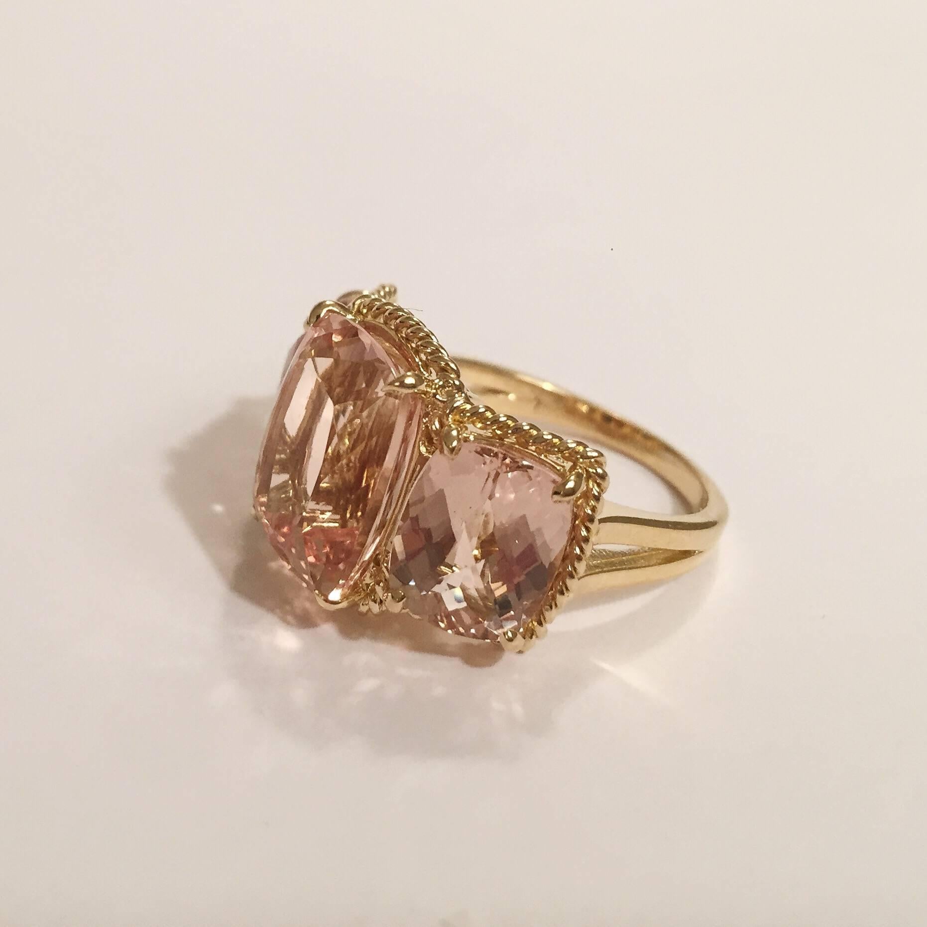 Elegant 18kt Yellow Three Stone Ring with Rope Twist Border with split shank detail. The ring features three faceted cushion Cut Morganite all surrounded by twisted gold rope. 
  The center morganite measures 5/8" tall (including the rope