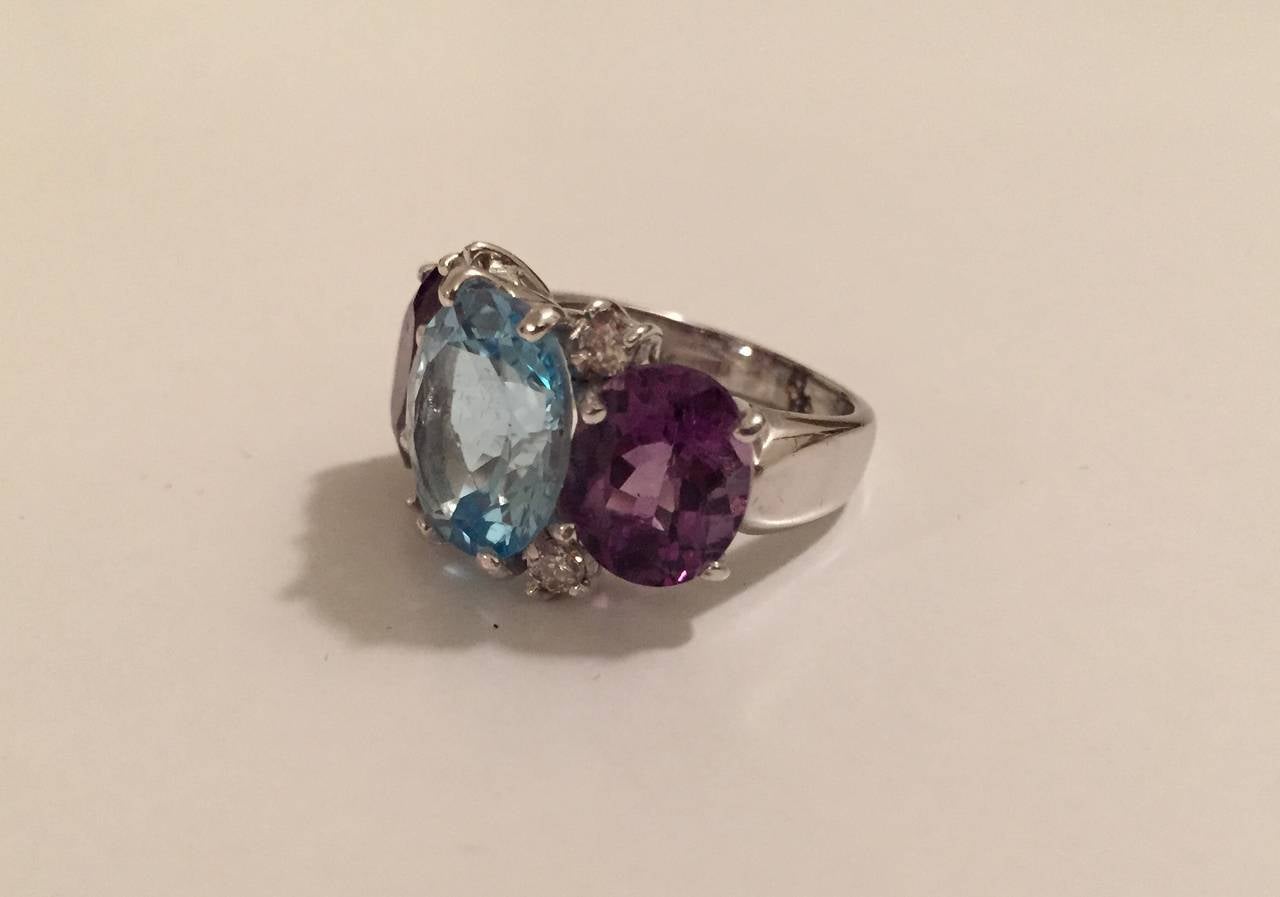 18kt Medium Three Stone GUM DROP™ Ring with Pale Blue topaz, Violet Amethyst, and four diamonds weighing approximately .40 cts

This beautiful ring measures ~ 1