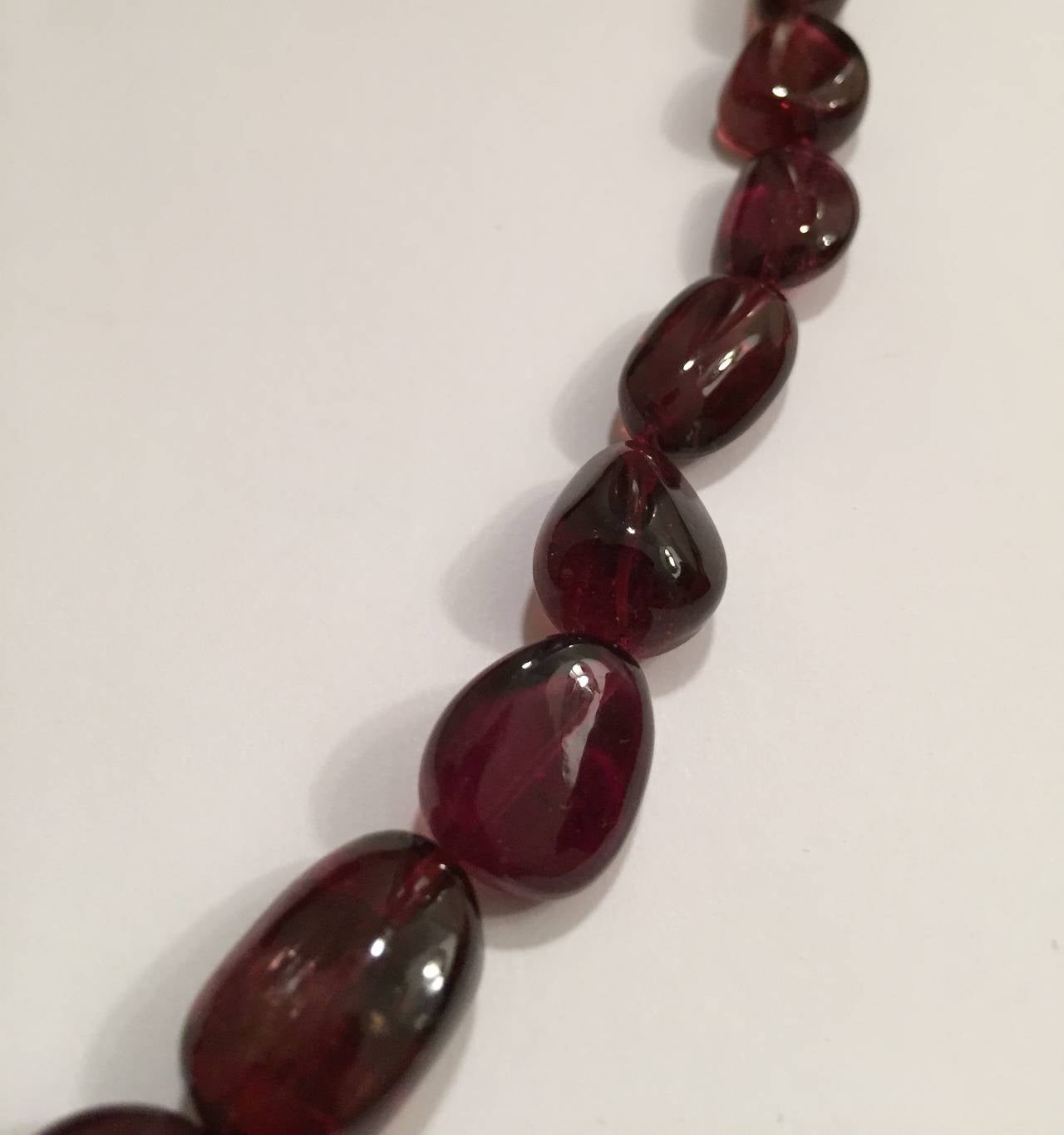 Elegant Rubleite Bead Necklace finished with an 18kt Yellow Gold clasp.  The The beautiful deep hue is perfect to pair with all seasons of fashion.

The graduated beads measure 22mm to 8 mm in length.  The necklace is finished at 17