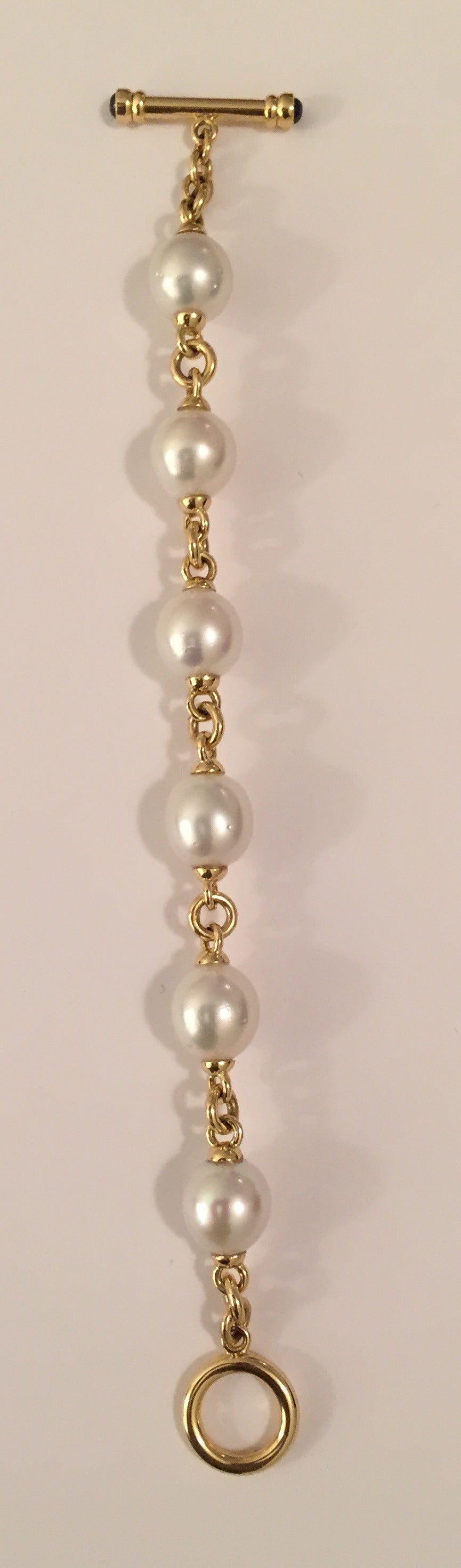 18kt Yellow Gold link and South Sea Pearl Bracelet with 6 South Sea pearls measuring 12 x 14 mm finished with gold toggle accented with 2 sapphires cabochon on each end.

Made to measure any size wrist.

Please contact us with any inquiries you