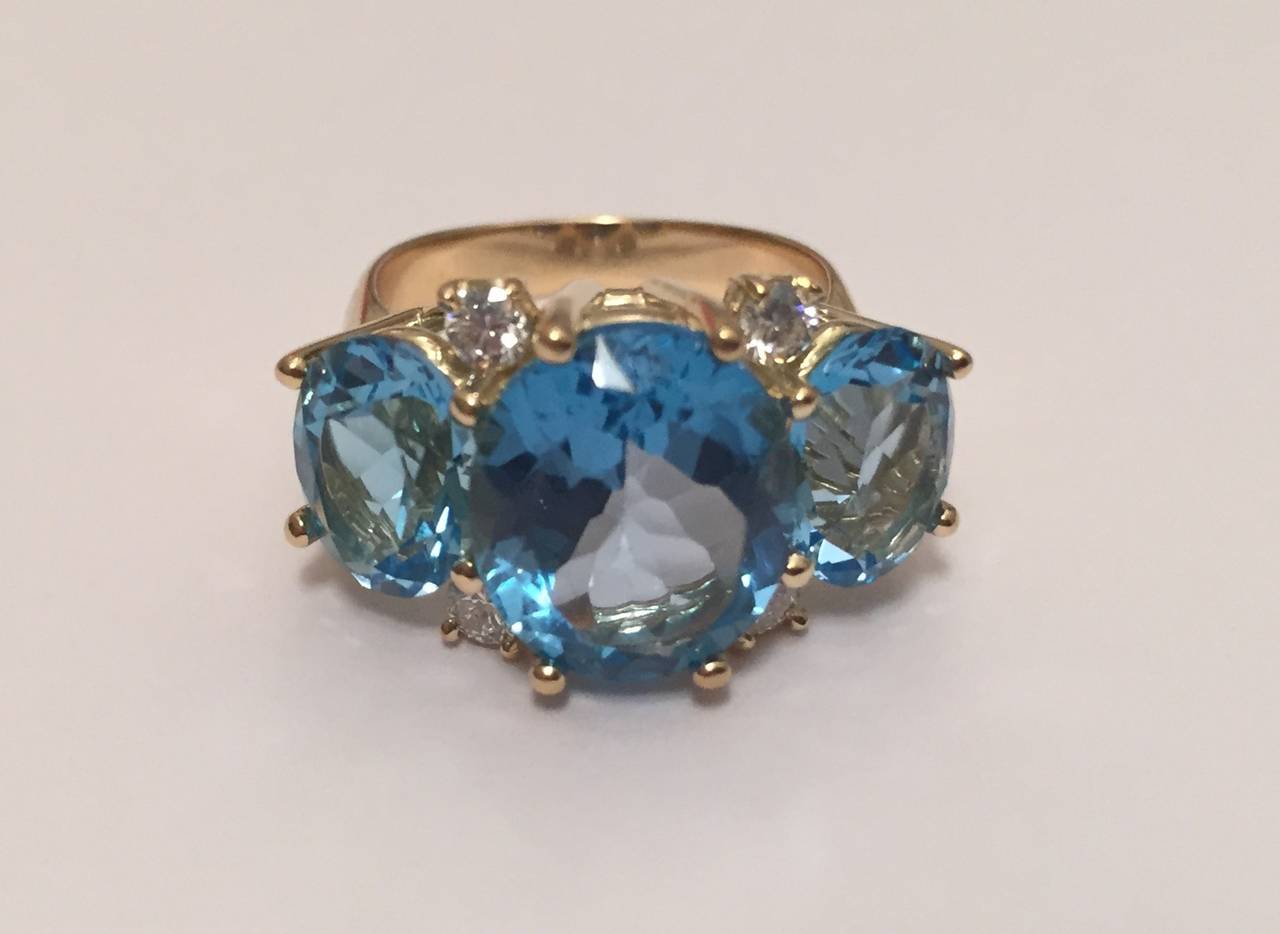 18kt Yellow Gold Medium GUM DROP™  with three Blue Topaz and four Diamonds weighing approximately 0.45cts.  The elegant scaling of the larger center stone with the smaller side stones makes this a modern interpretation of a classic three stone ring.
