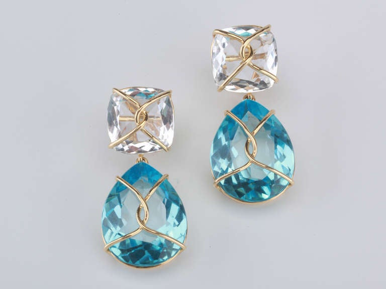 18kt Yellow Gold Drop Earring with gold wrapped faceted cushion shaped Rock Crystal top and faceted pear shaped blue topaz drop.

This elegant earring measures and inch and a half long. The top cushion is shaped Rock Crystal that measures half an