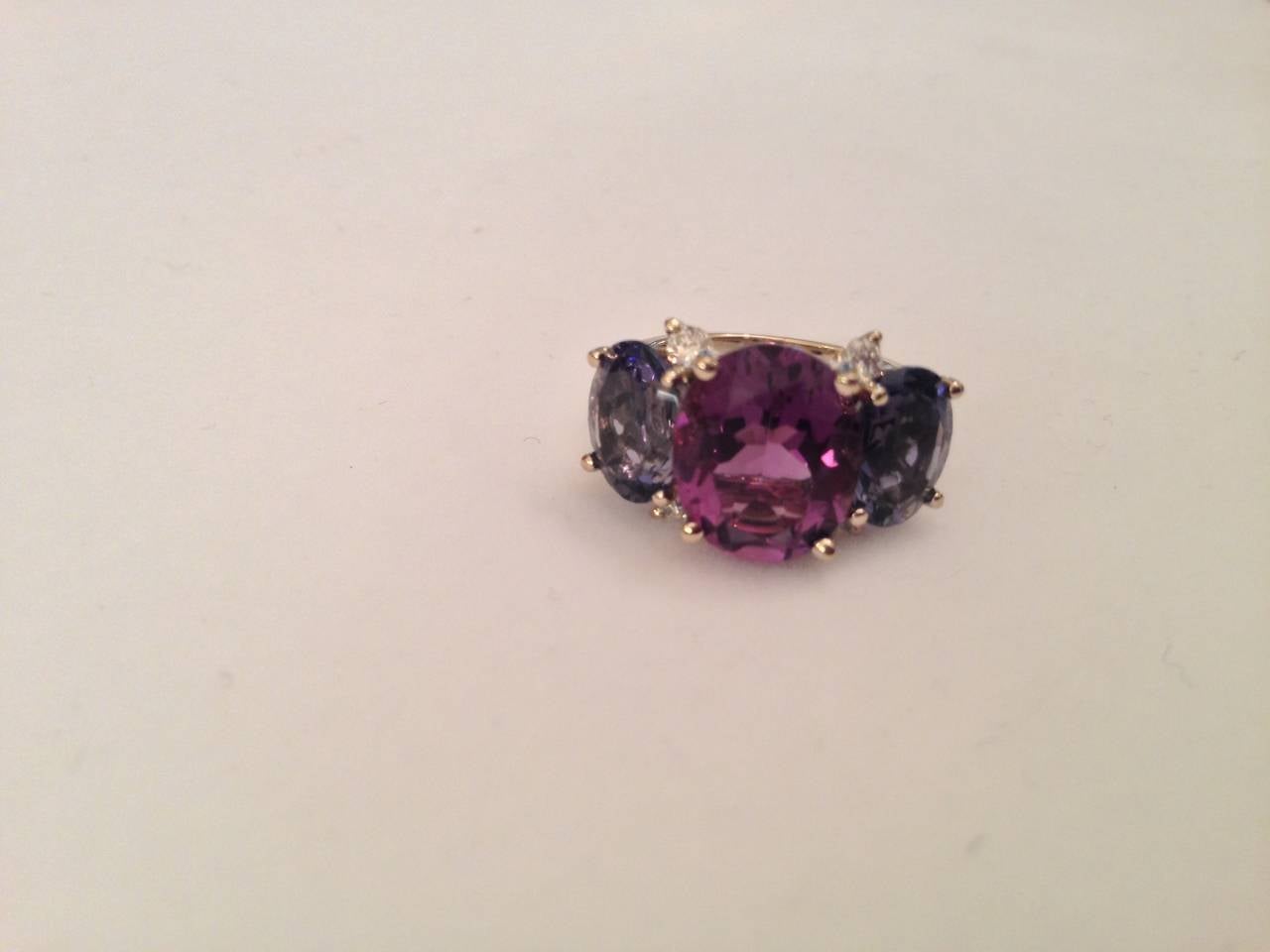 Elegant Three Stone Ring - For day or Evening.
18kt Yellow Gold Medium GUM DROP™ Ring with Facted center Amethyst and two faceted Iolite and four Diamonds ~0.40cts.

The ring can be sized or ordered to your ring size.

The GUM DROP™ Ring