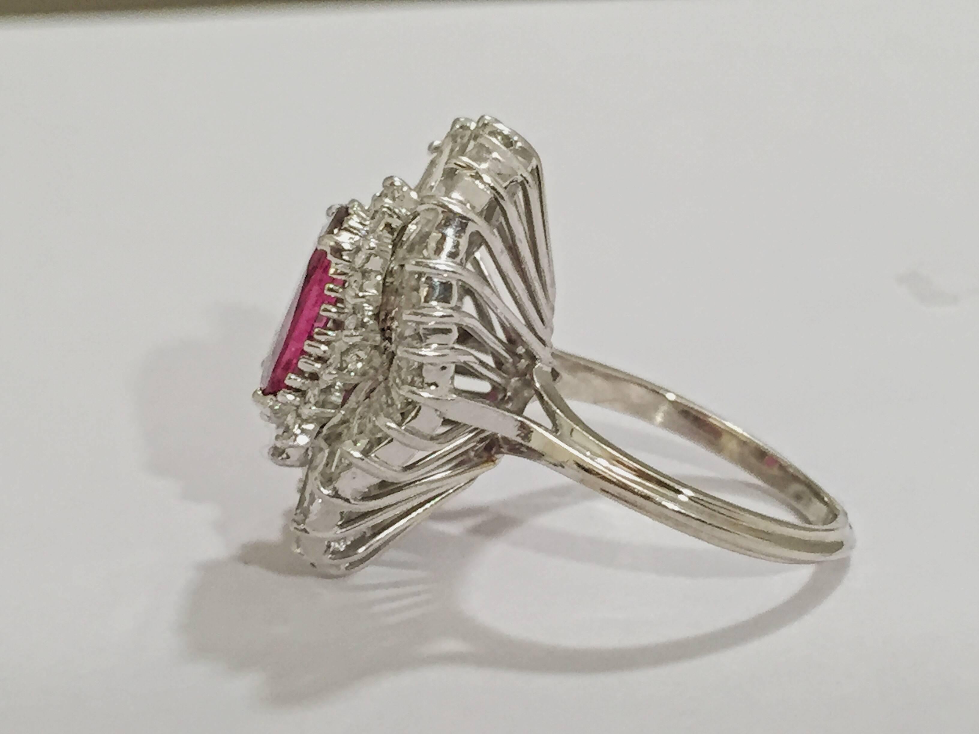 18kt White Gold Ruby and baguette and round Diamond Ring.  The ring has a center oval ruby and is surrounded by approximately 20 round diamonds and  30 baguette diamonds creating a wave effect.

The Ruby is approximately 4 carats and the diamonds