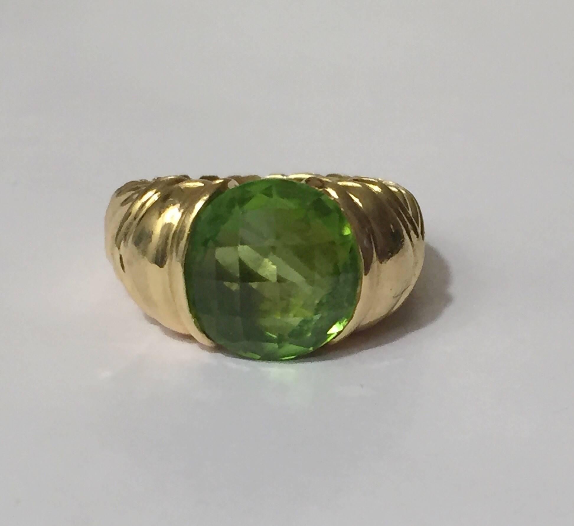 David Yurman 18kt Yellow Gold and faceted cushion cut Peridot Ring with signature cable designs.  The ring can be sized but is in original condition.