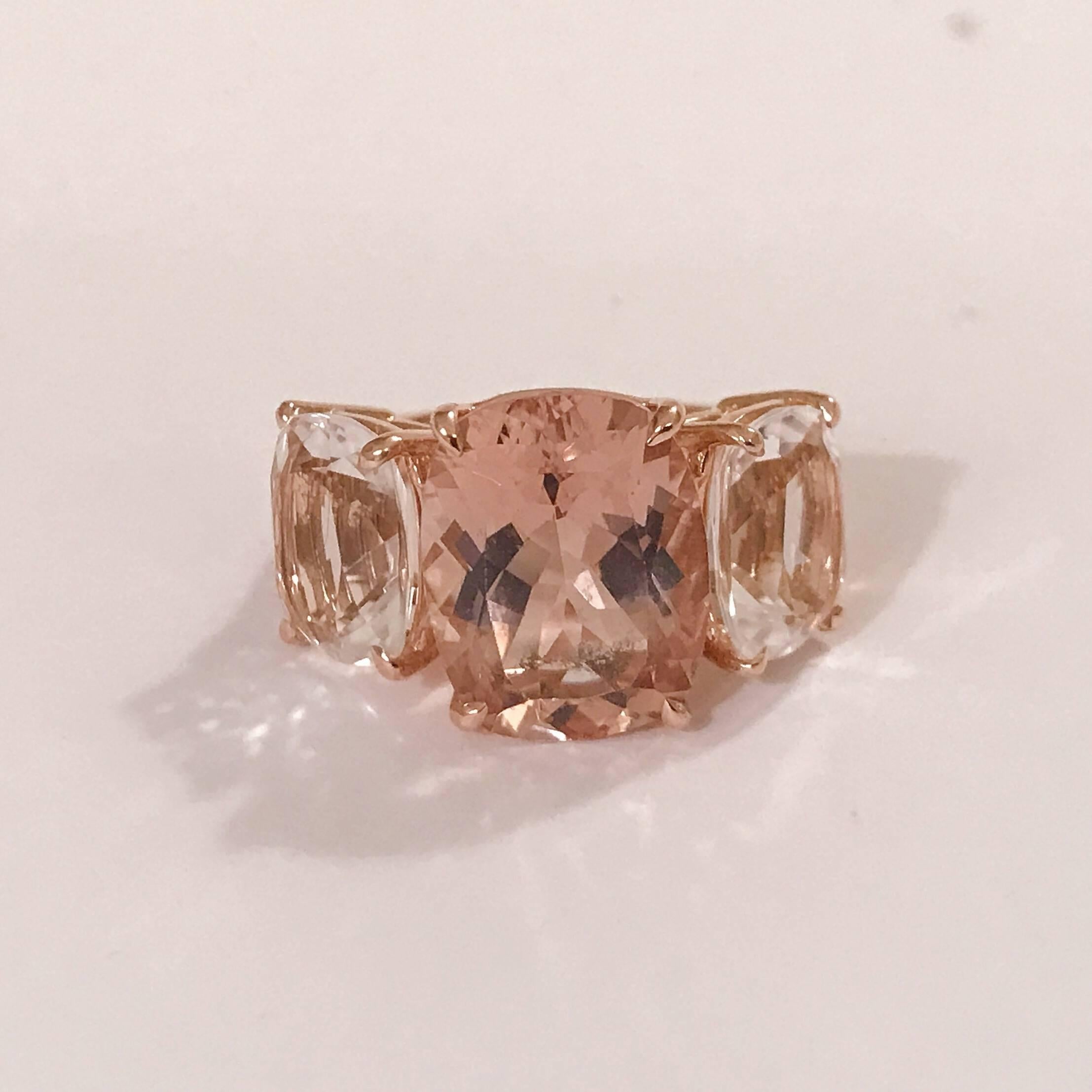 Anello a cuscino con tre pietre sfaccettate in oro rosa 18 carati con Morganite centrale e due cristalli di rocca, rifinito con un gambo affusolato.  
Questo elegante anello da cocktail misura 1  1/4
