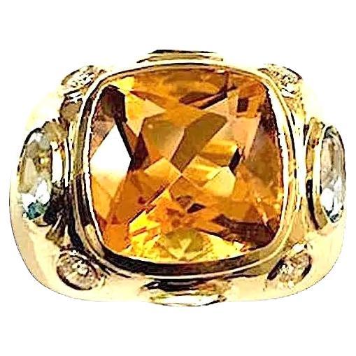 Anillo BONHEUR: Anillo abombado de oro amarillo de 18 quilates con citrino facetado, piedra central talla cojín y dos peridotos ovales facetados y dos topacios azules pálidos ovales facetados y diamantes redondos. 
Una elegante vitola o anillo de
