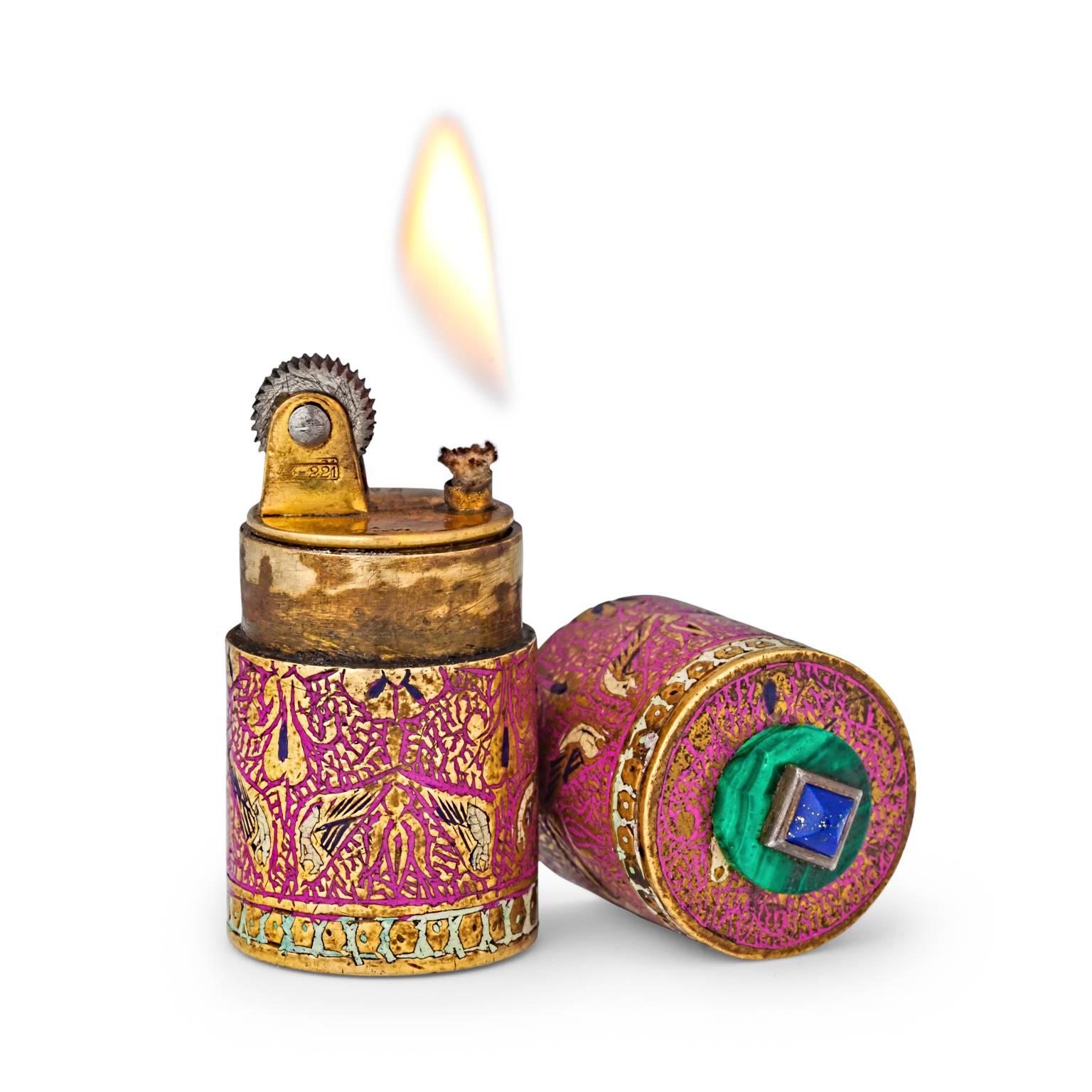 Light up your life with this colorful cloisonne enamel Art Deco, circa 1920, Cartier lighter.  This rare cylindrical lighter is elegantly enameled with a delicate bird and leaf design and topped with malachite and lapis stone accents making it both