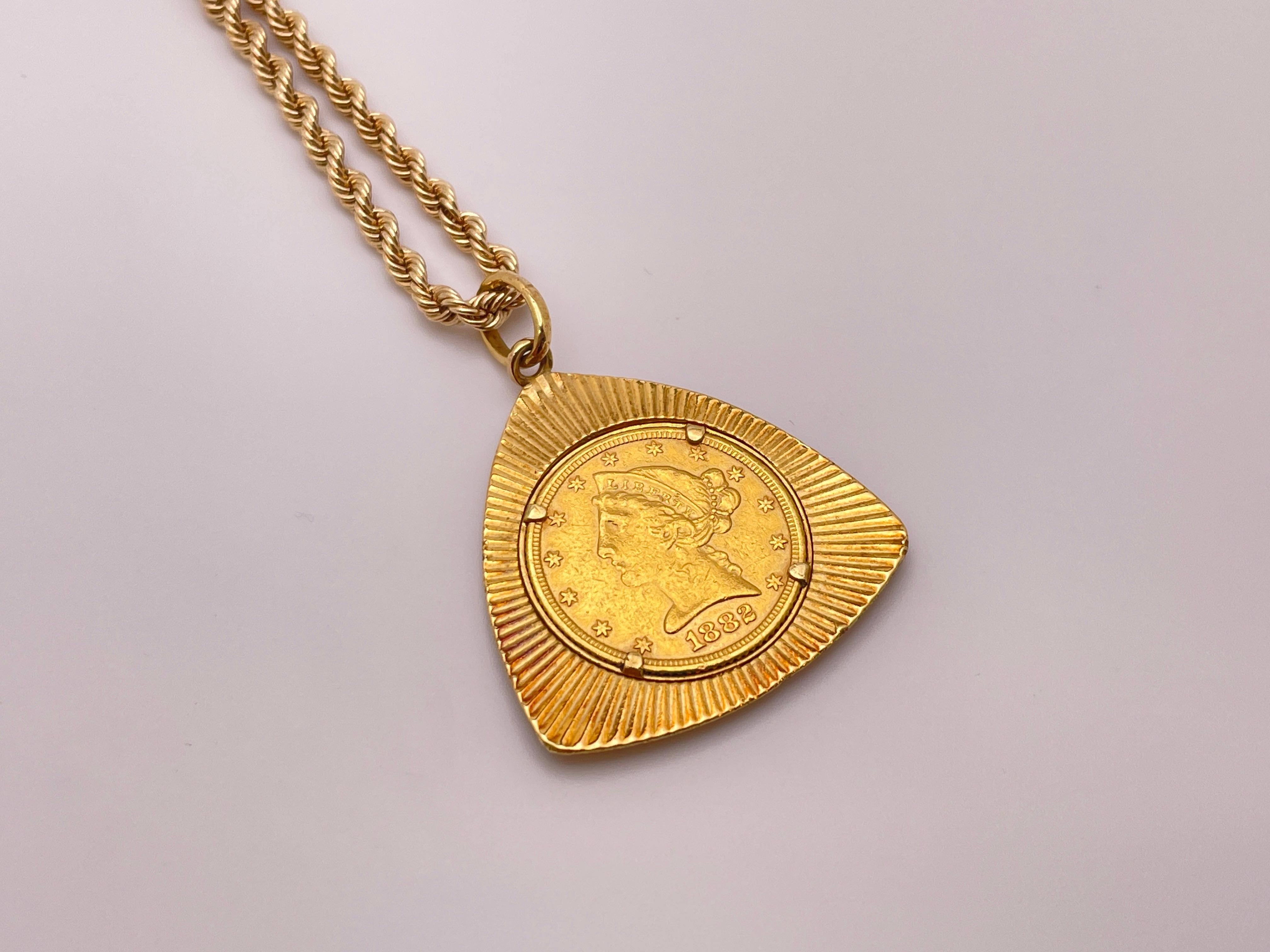 An 1882 $5 gold Lady Liberty Eagle coin pendant, mounted in an 18K yellow gold radiating triangular frame, accompanied by a 14K yellow gold 20.50 inch chain.

