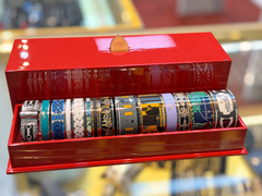 26 bracciali rigidi vintage Hermès con motivi smaltati, in diverse larghezze e con i relativi espositori