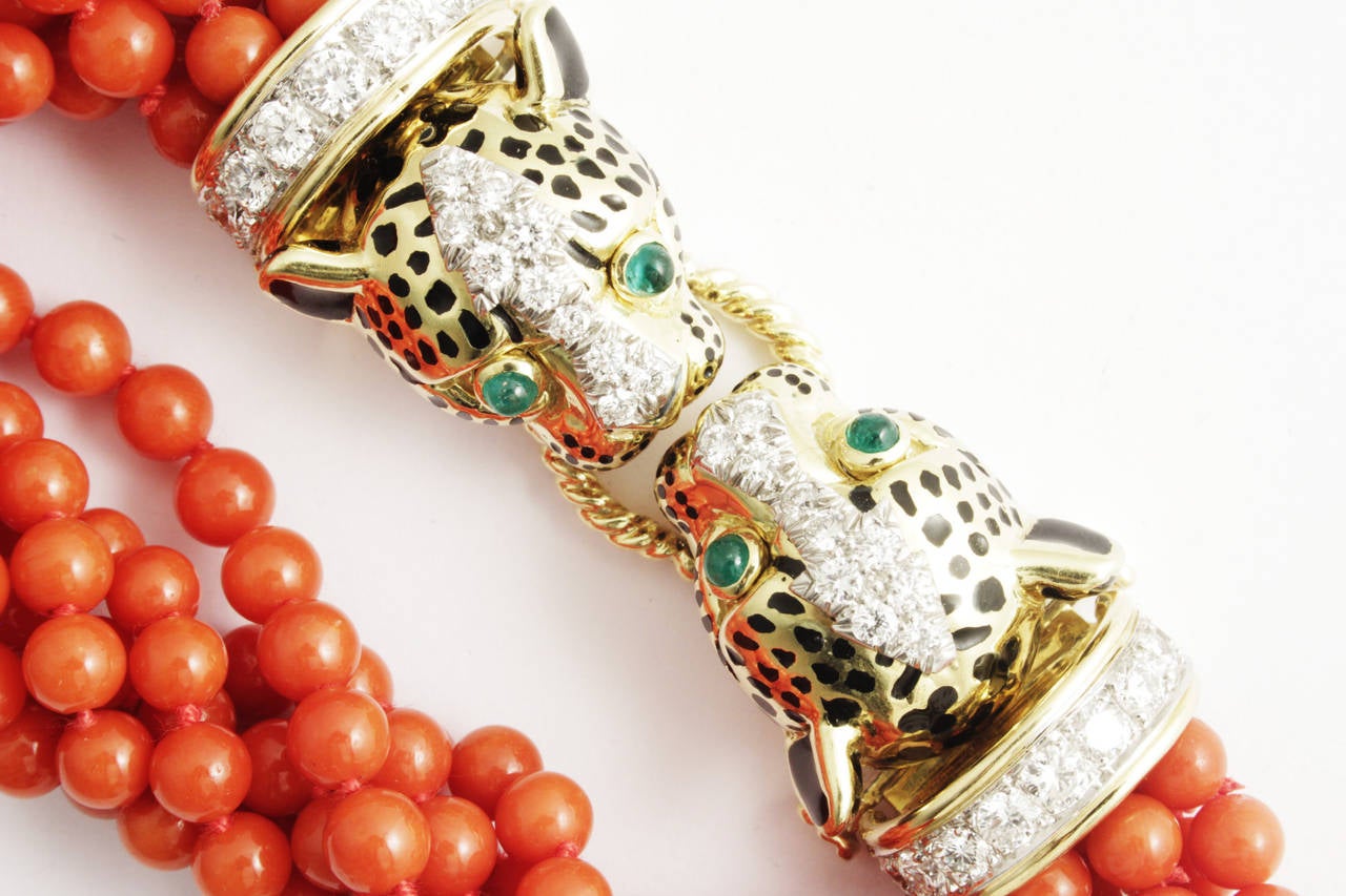 An exquisite bracelet composed of several strands of twisted fine red coral beads, united by a gold clasp representing two tiger heads biting on to a circular rope, evoking the iconic animalier theme typical of the house, embellished by diamonds,