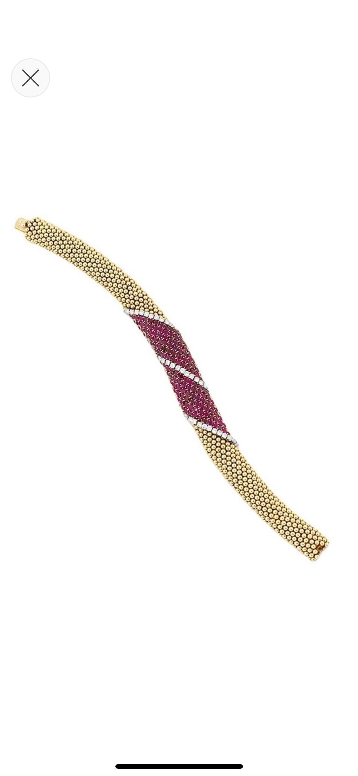 Of flexible tubular design, composed of a clustered band of polished spherical beads to a central pavé-set circular-cut ruby panel with diagonal brilliant-cut diamond line highlights, to a concealed clasp. Made in France, circa 1965, with French